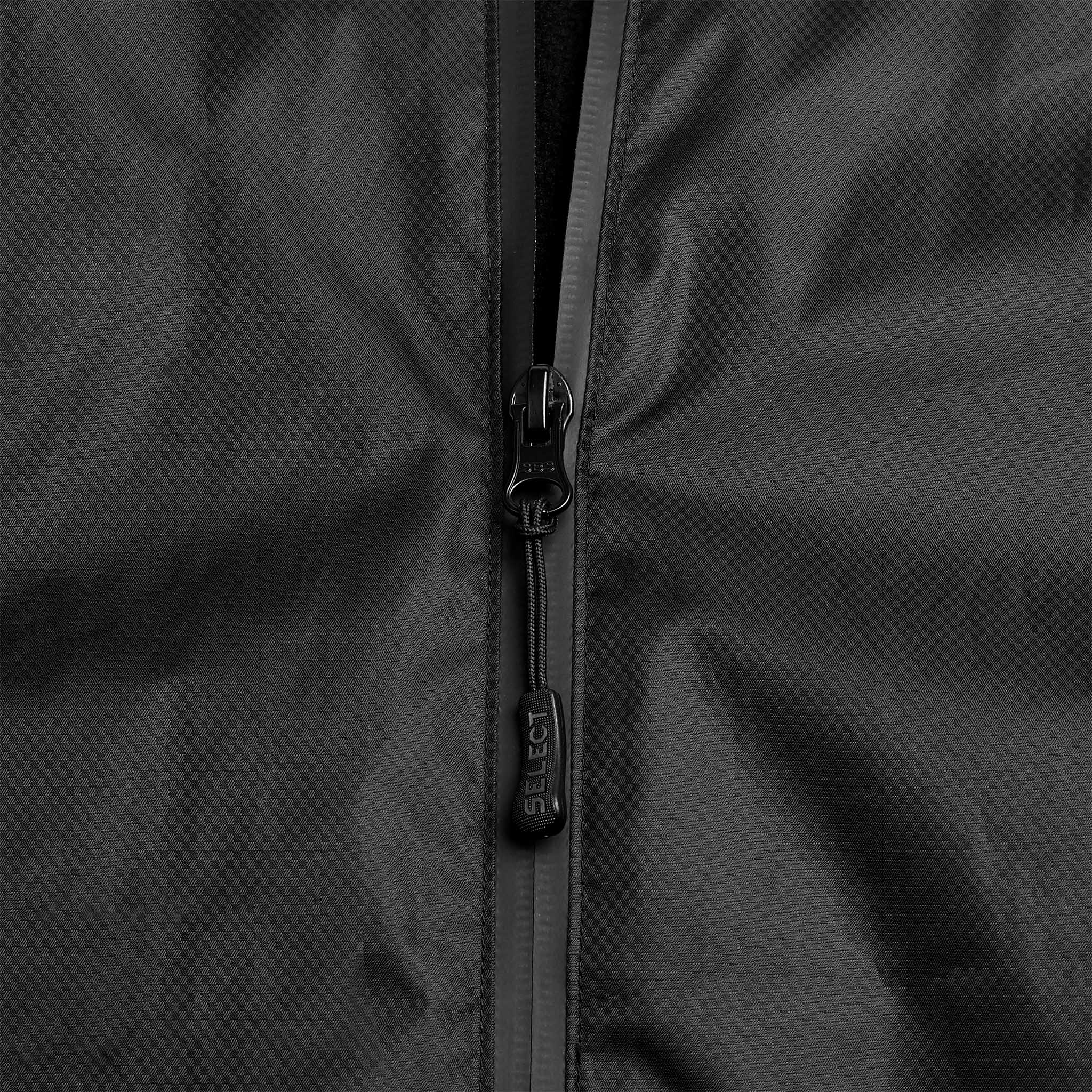 Closeup of black Functional jacket Monaco v24, Match & Training wear, showing zipper detail on textured fabric.