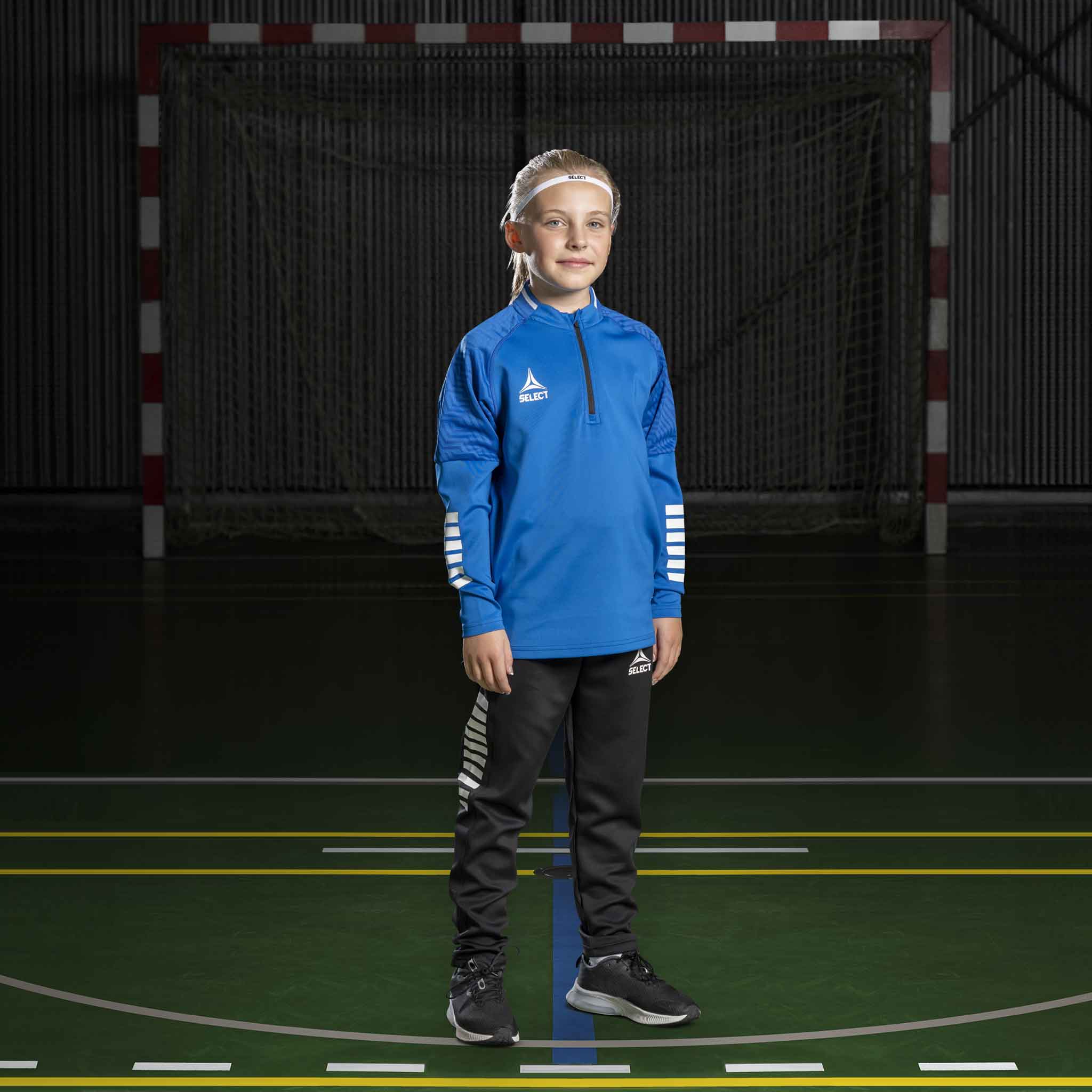 Boy handball player in blue Training sweat 1/2 zip Monaco v24, black pants. Match & Training wear, front view.