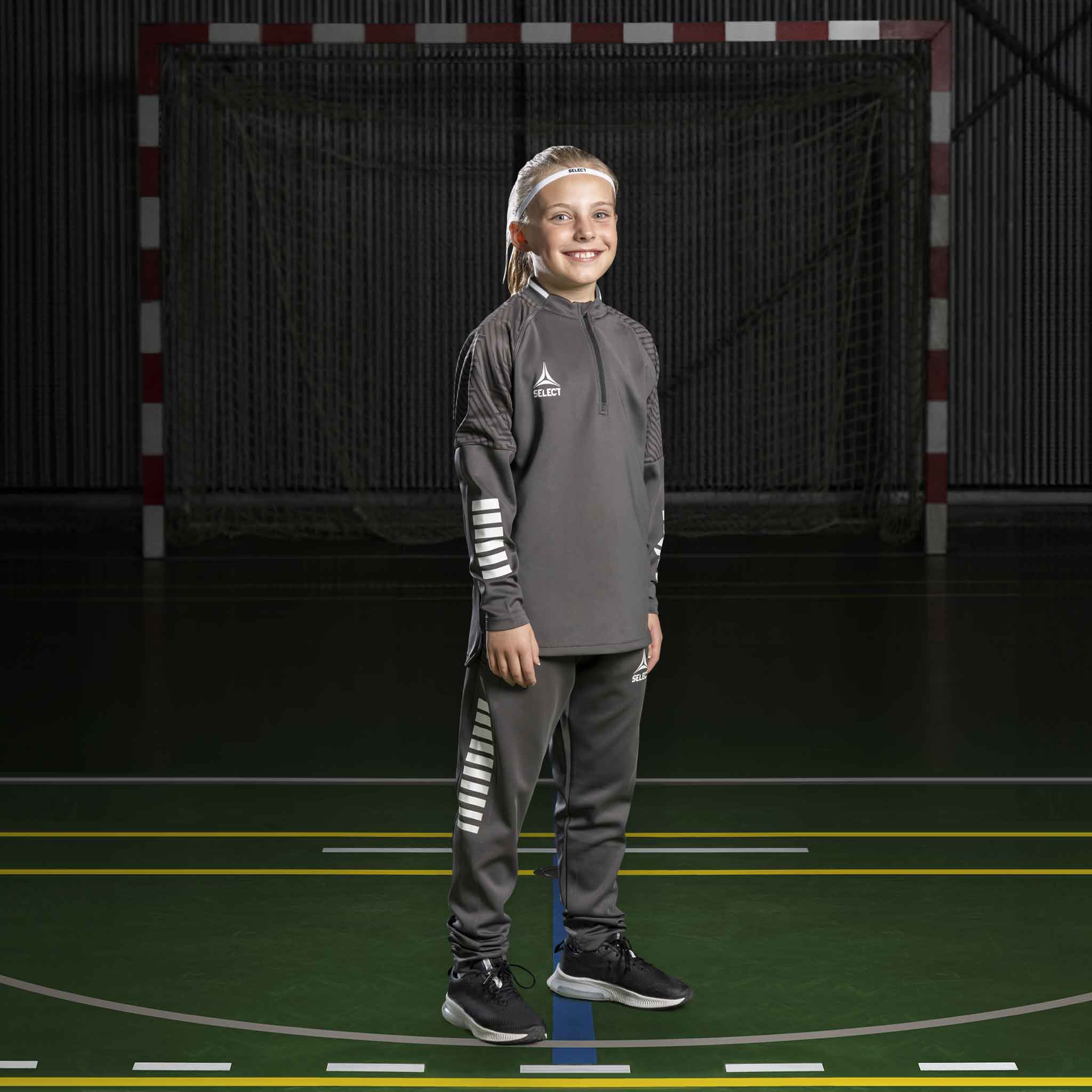 Girl handball player in grey Training sweat 1/2 zip Monaco v24, Match & Training wear, with white details on court.