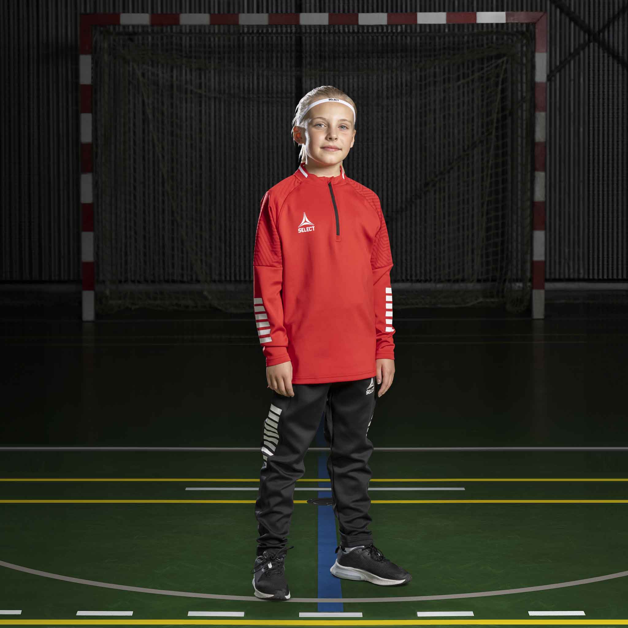 Boy handball player in red Training sweat 1/2 zip Monaco v24, Match & Training wear, with black pants on court.