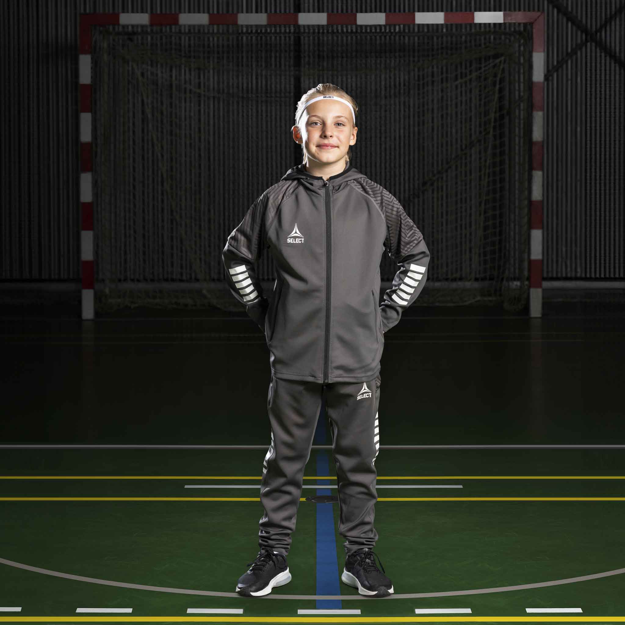 Boy handball player in grey and white Zip hoodie Monaco v24, Match & Training wear, front view on court.