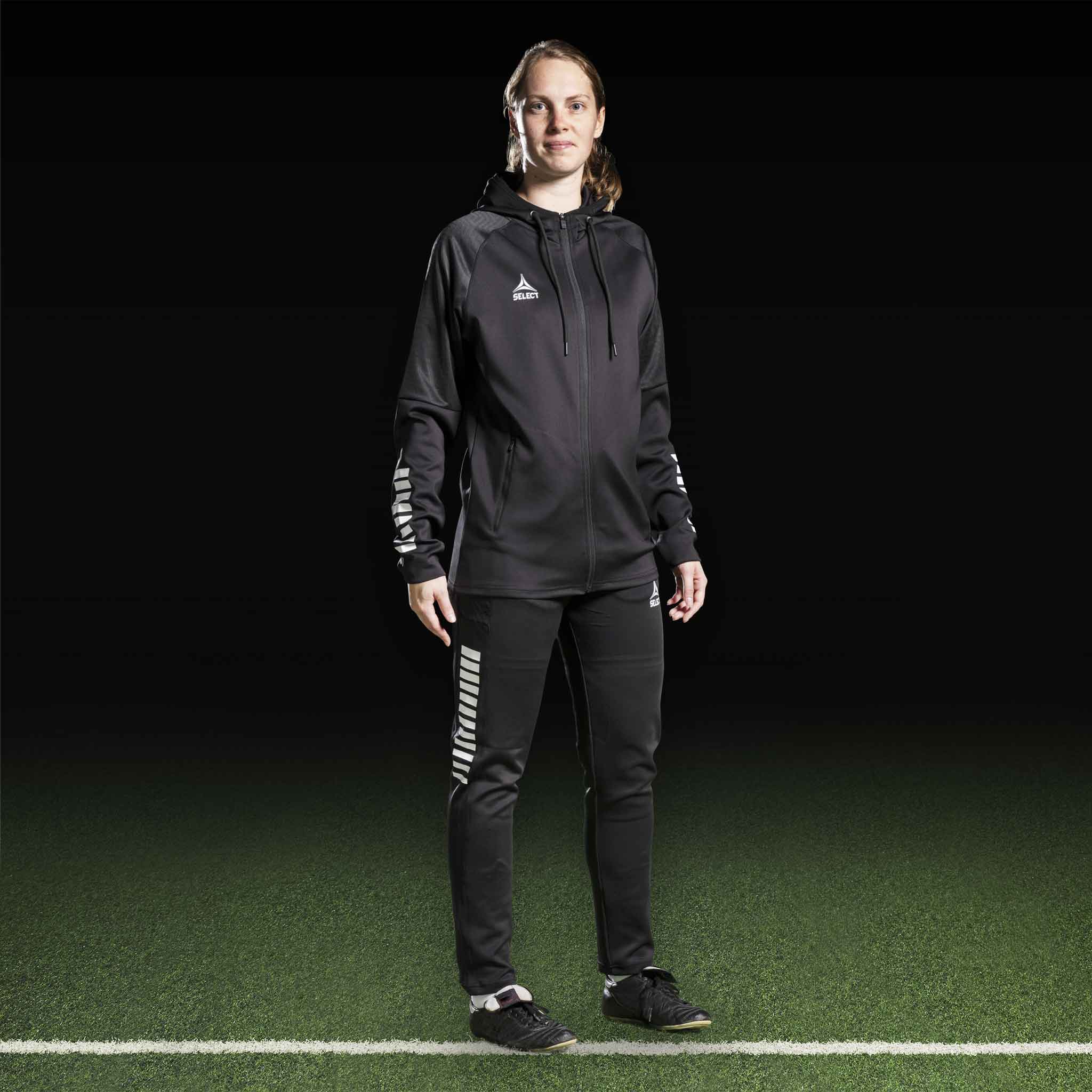 Female football player in black and white Zip hoodie Monaco v24, Match & Training wear, front view on pitch.
