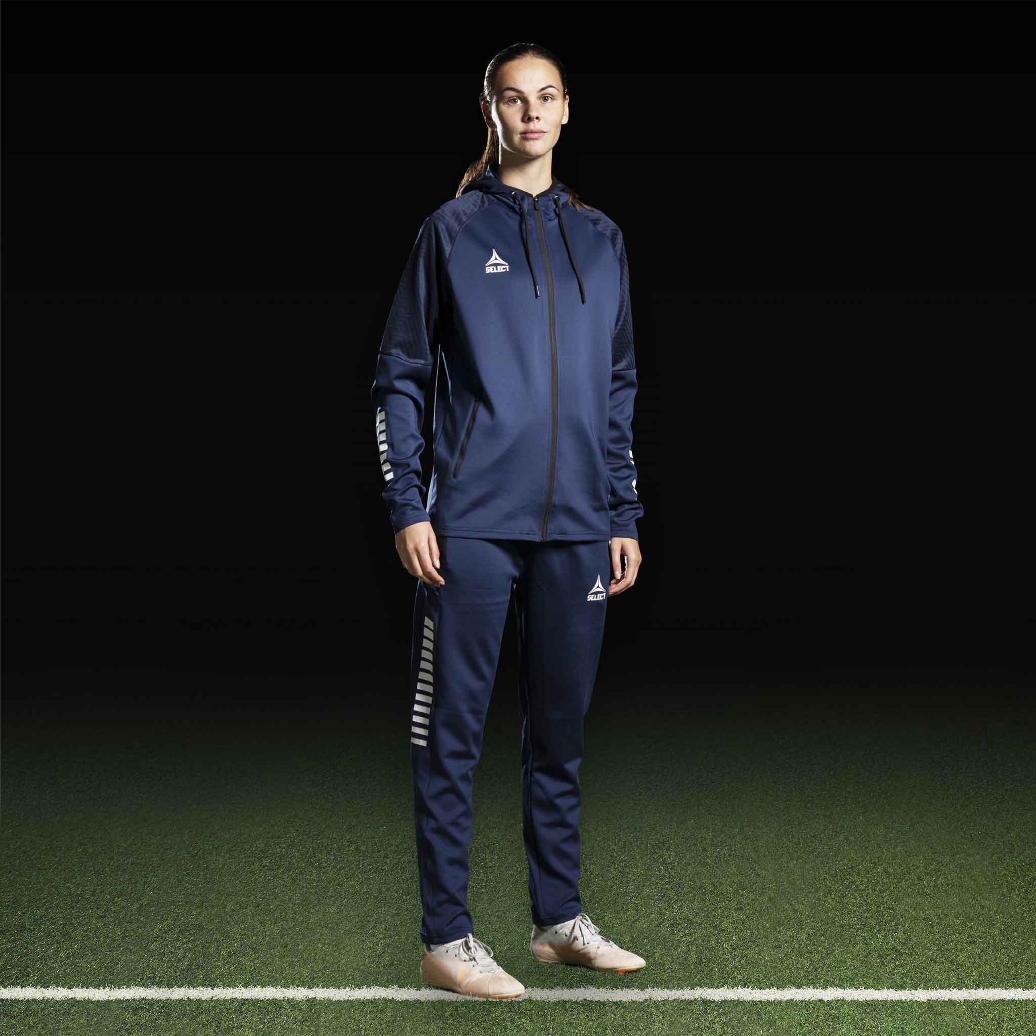 Female football player in navy Zip hoodie Monaco v24, Match & Training wear, front view with white logo details.