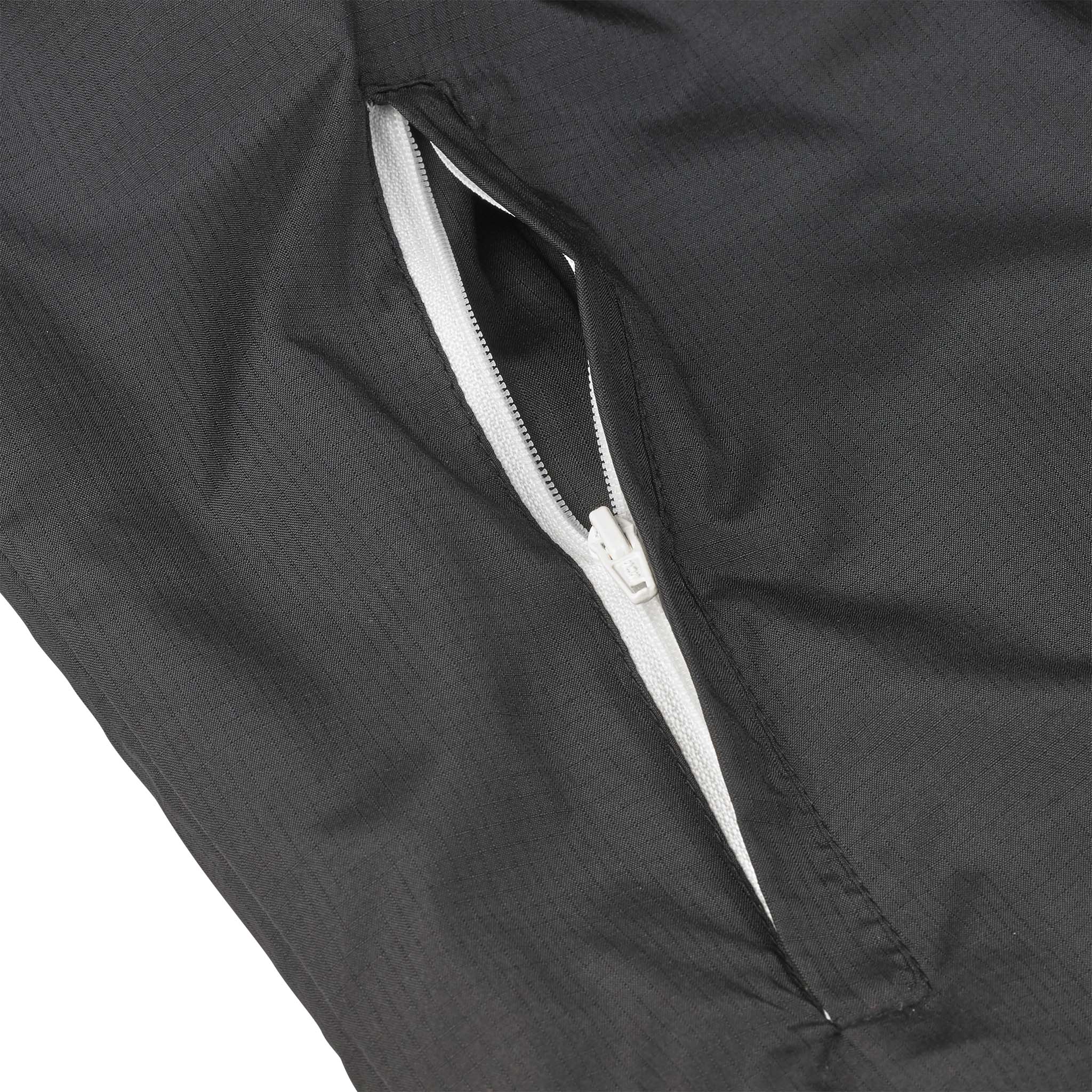 Closeup of black Training jacket Spain v25, Match & Training wear, showing white zip pocket detail.