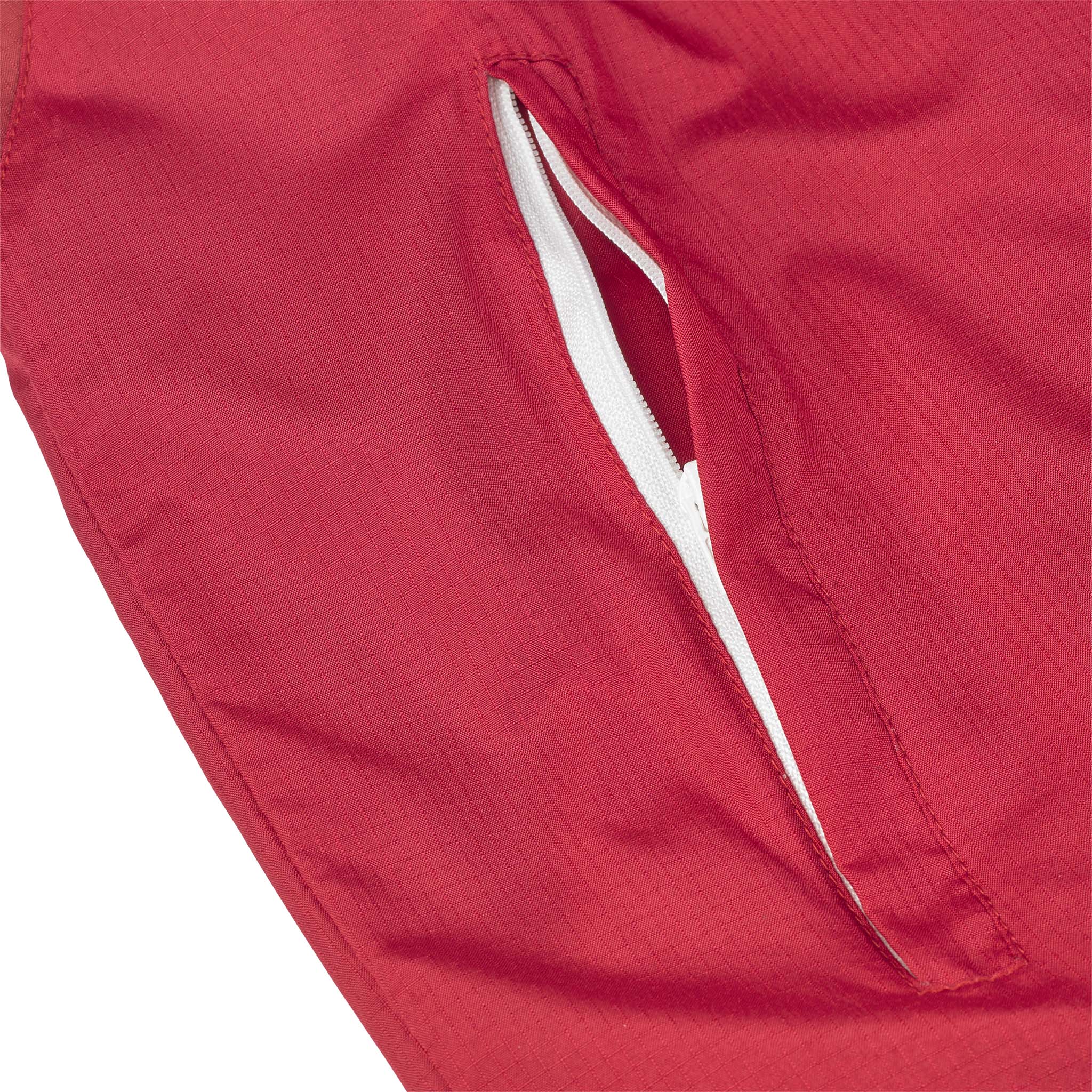 Closeup of red Training jacket Spain v25, Match & Training wear, showing white-lined zip pocket detail
