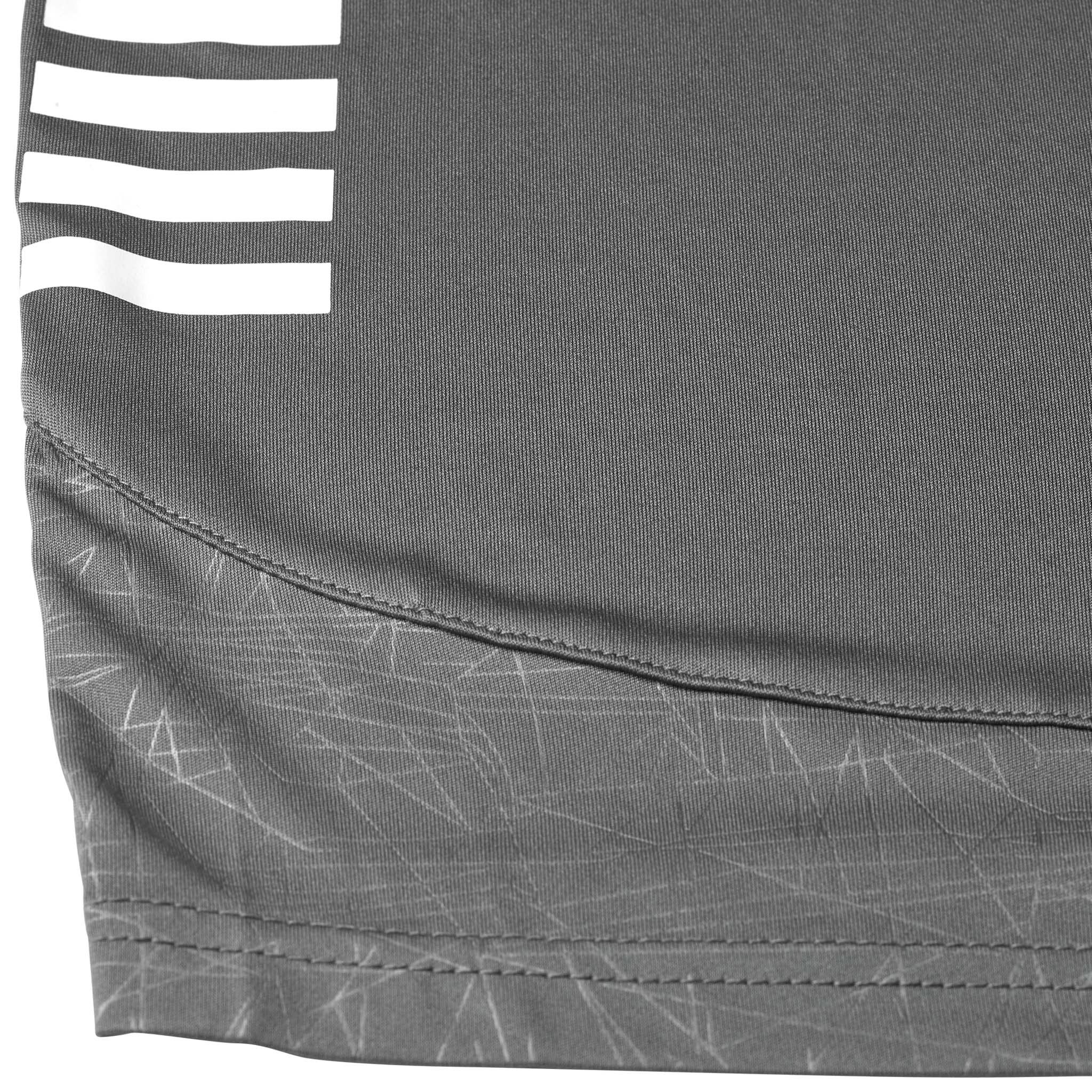 Closeup of grey Player shorts Spain v25, Match & Training wear, with white stripes and geometric pattern hem