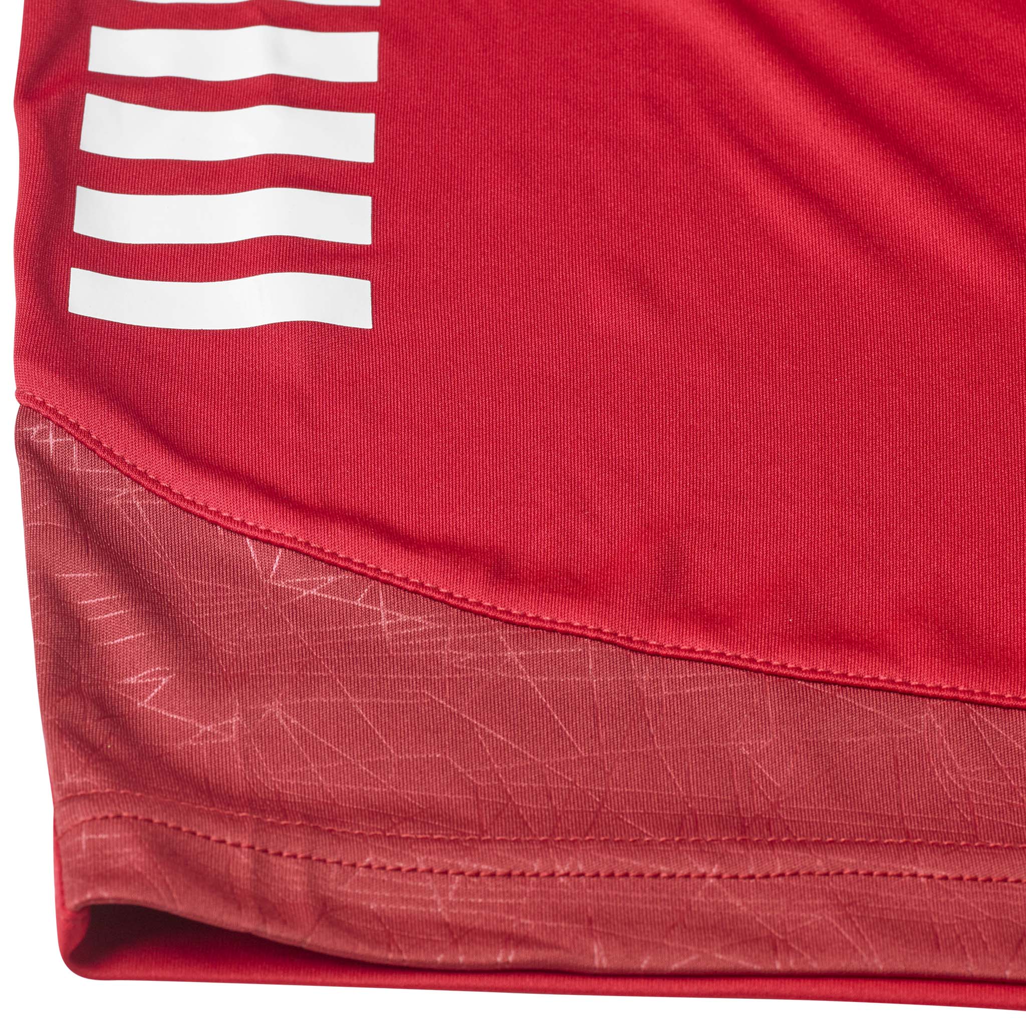 Closeup of red Player shorts Spain v25, Match & Training wear, showing white stripes and patterned hem detail.