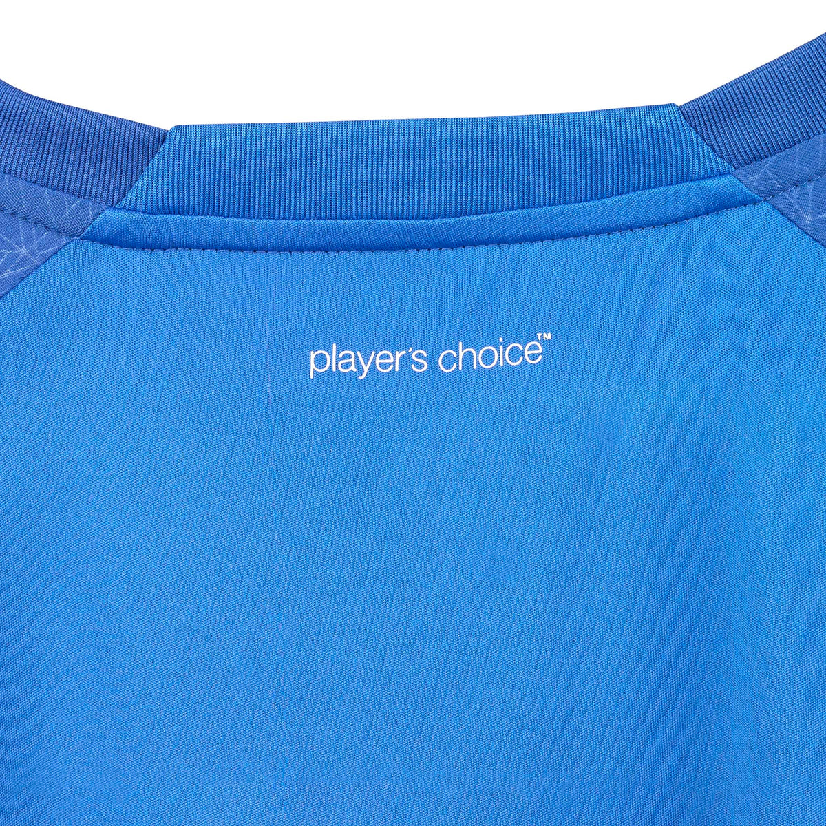 Closeup of blue Player shirt S/S Spain woman v25, Match & Training wear, white "player's choice" logo and collar detail.