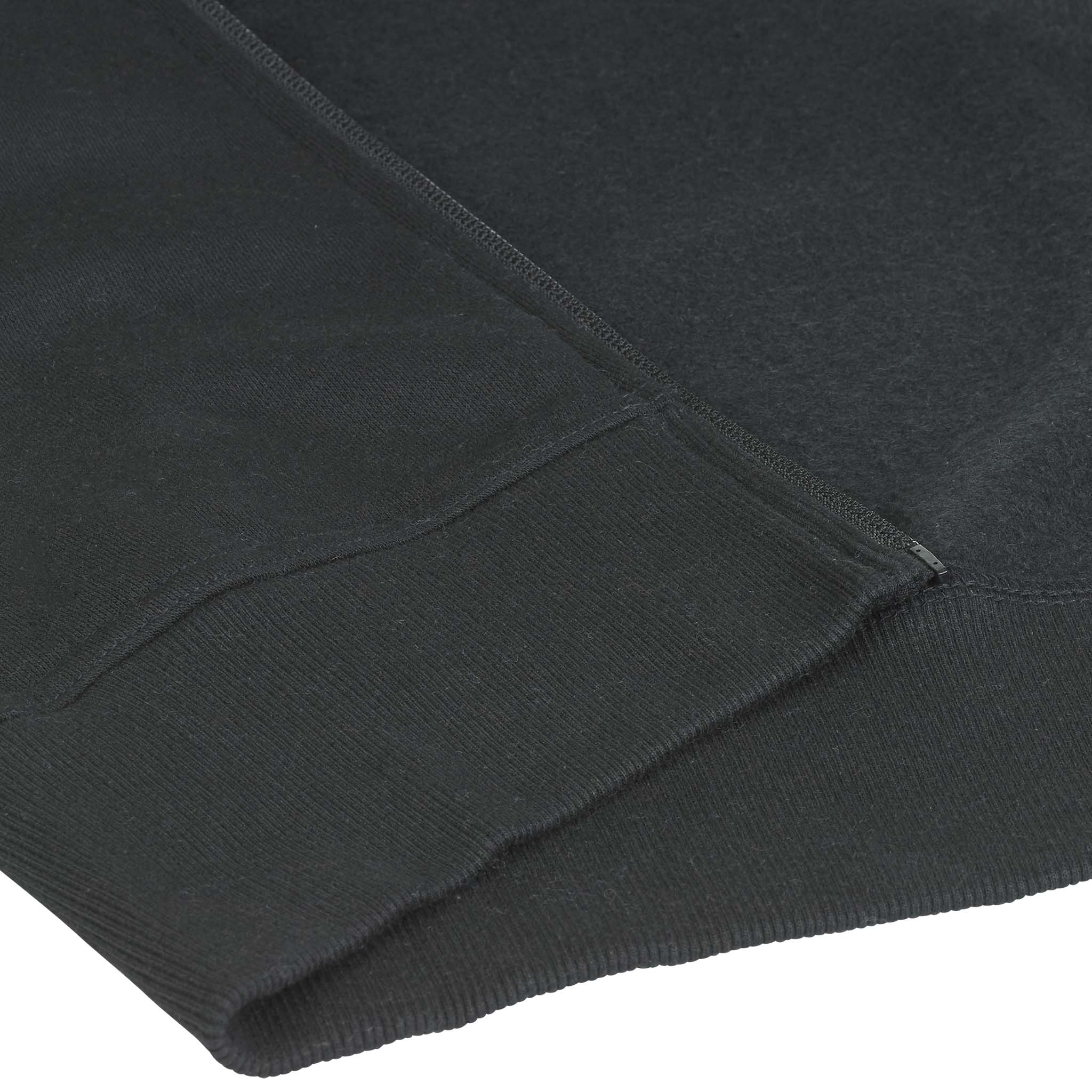 Closeup of black Zip hoodie Oxford v25 leisure wear, showing ribbed hem and pocket detail.
