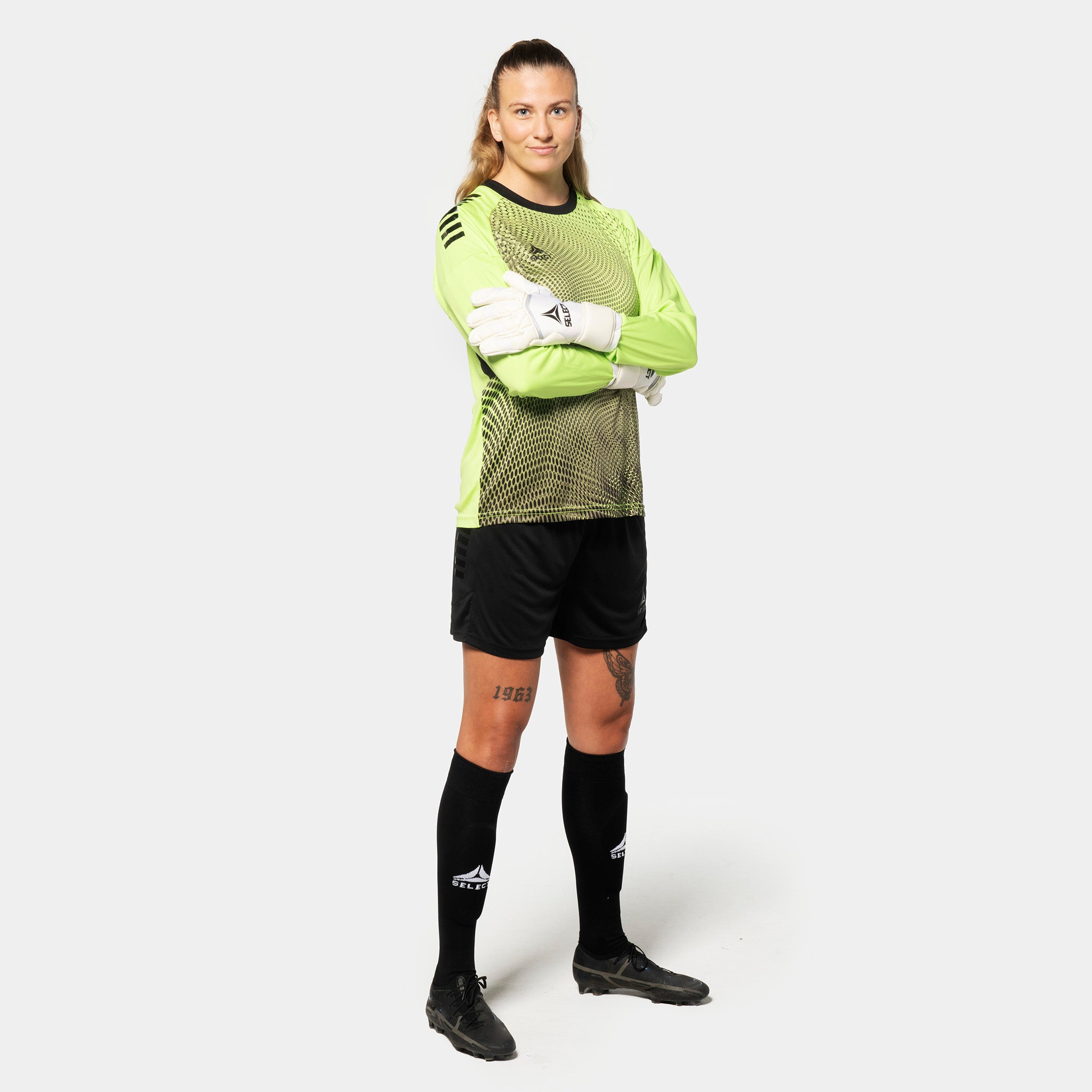 Female football player in lime green and black Goalkeeper shirt Spain v25, goalkeeper wear with black shorts and socks.