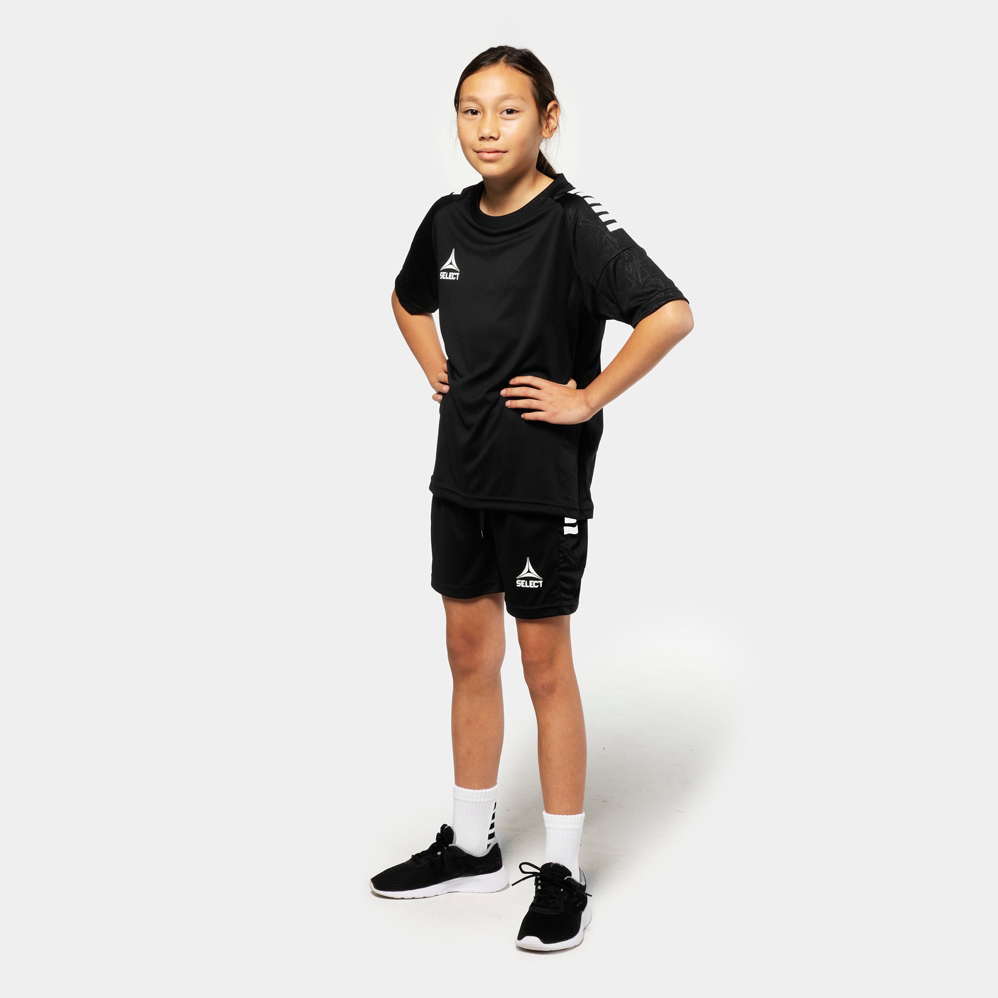 Girl football player in black Player shorts Spain v25 and matching shirt, Match & Training wear, front view.