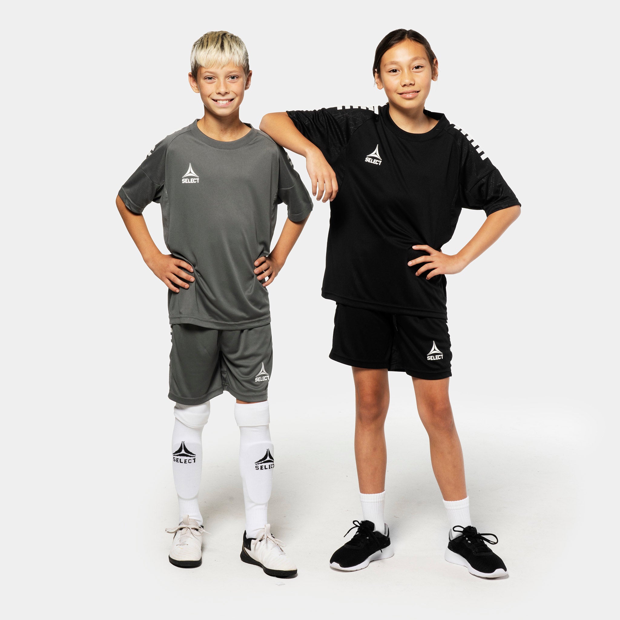 Boy and girl football players in grey and black Player shorts Spain v25, Match & Training wear, front view.