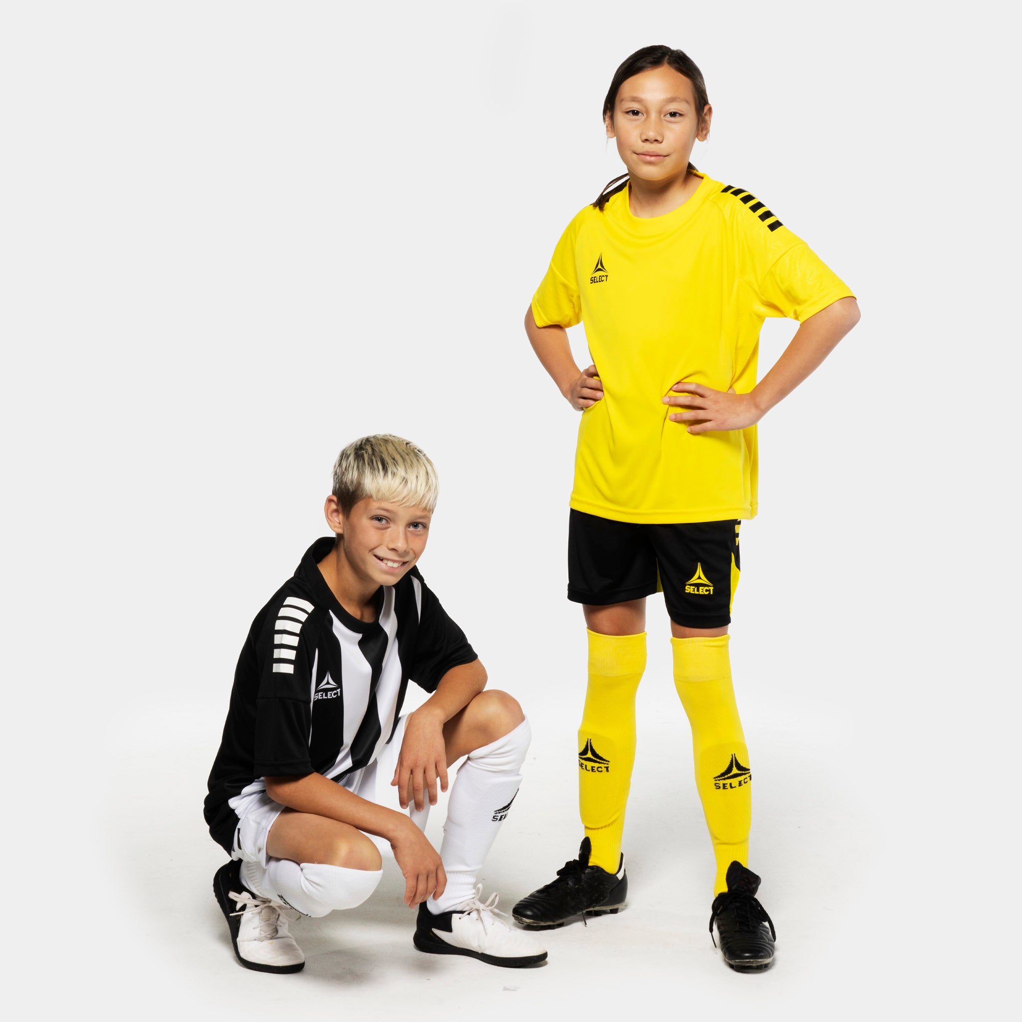 Boy and girl football players in black Player shorts Spain v25, Match & Training wear, front view.