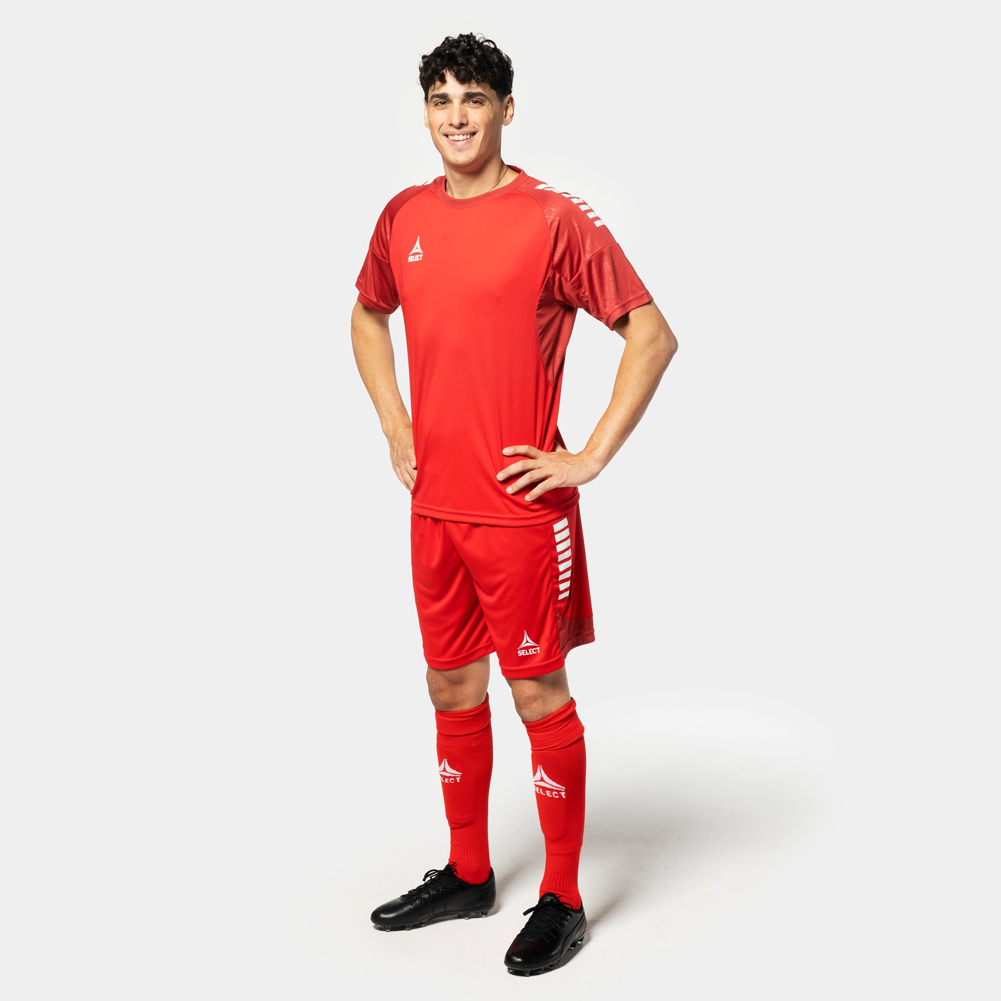 Male football player in red Player shorts Spain v25, Match & Training wear, with white side stripes, front view.