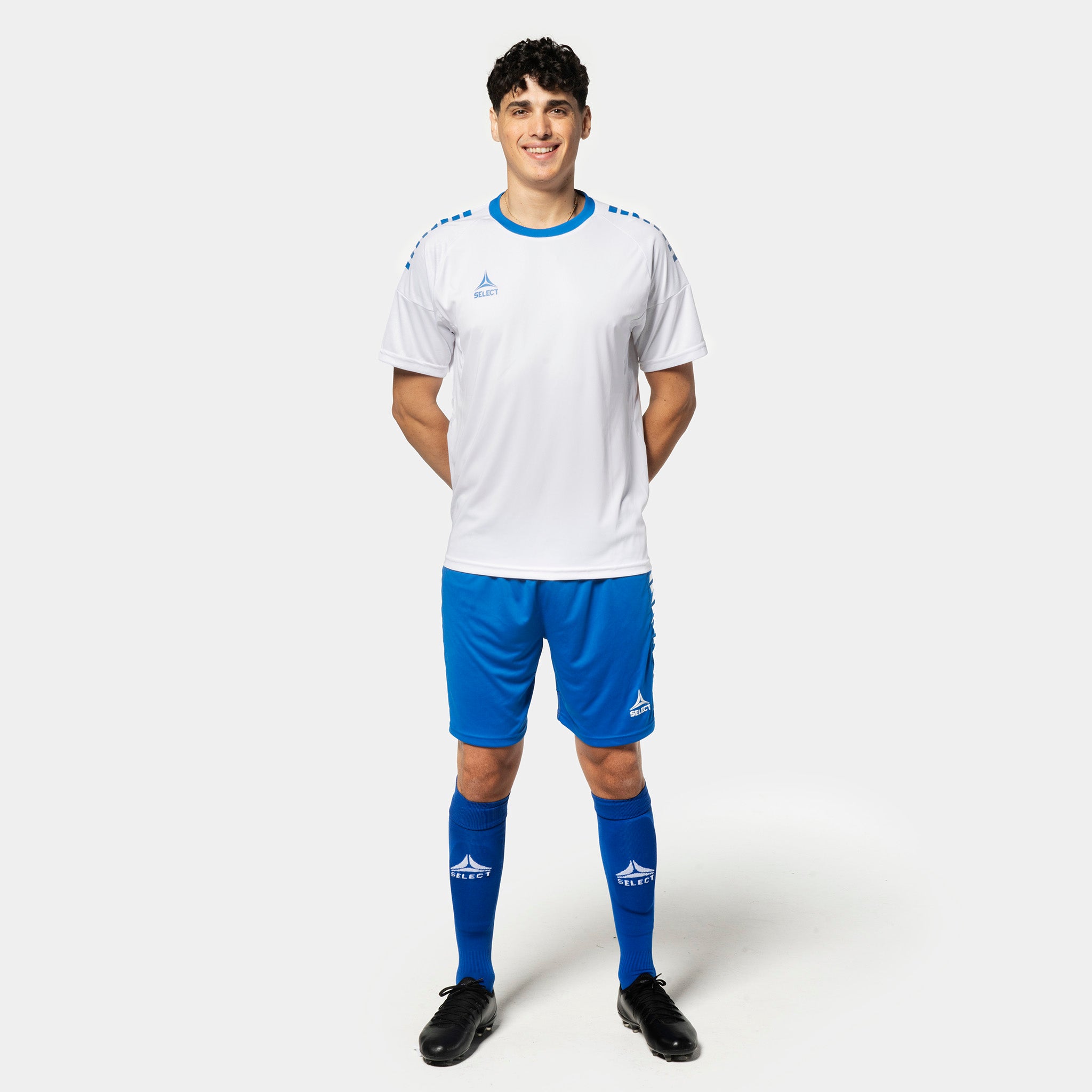 Male football player in white shirt and blue Player shorts Spain v25, Match & Training wear, front view.