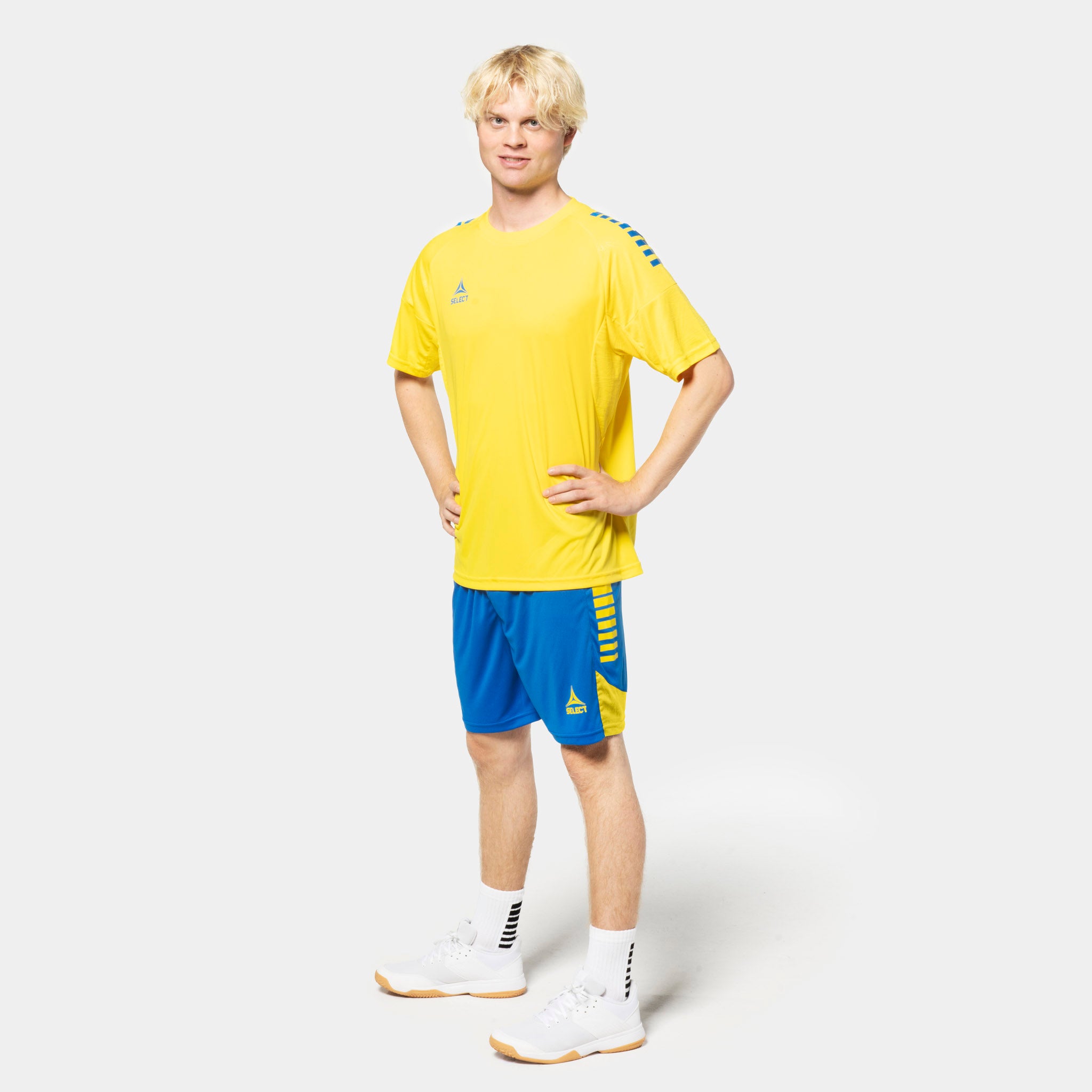 Male football player in yellow shirt and blue Player shorts Spain v25, Match & Training wear, front view.