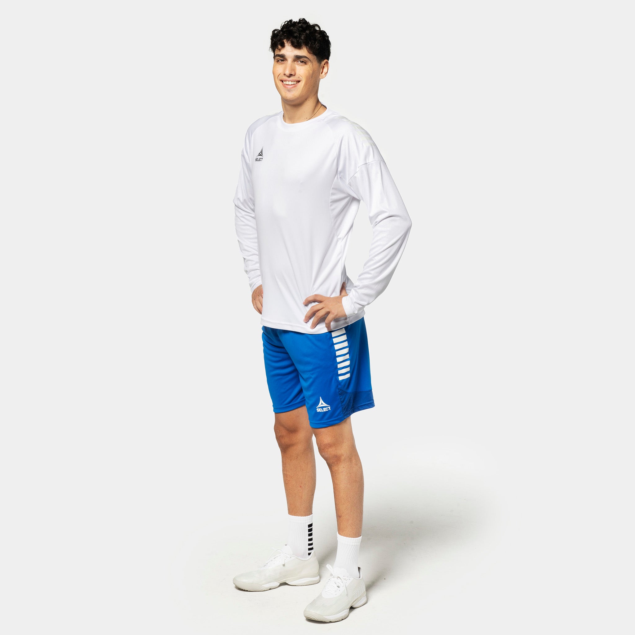 Male football player in white Player shirt L/S Spain v25 and blue shorts, Match & Training wear.