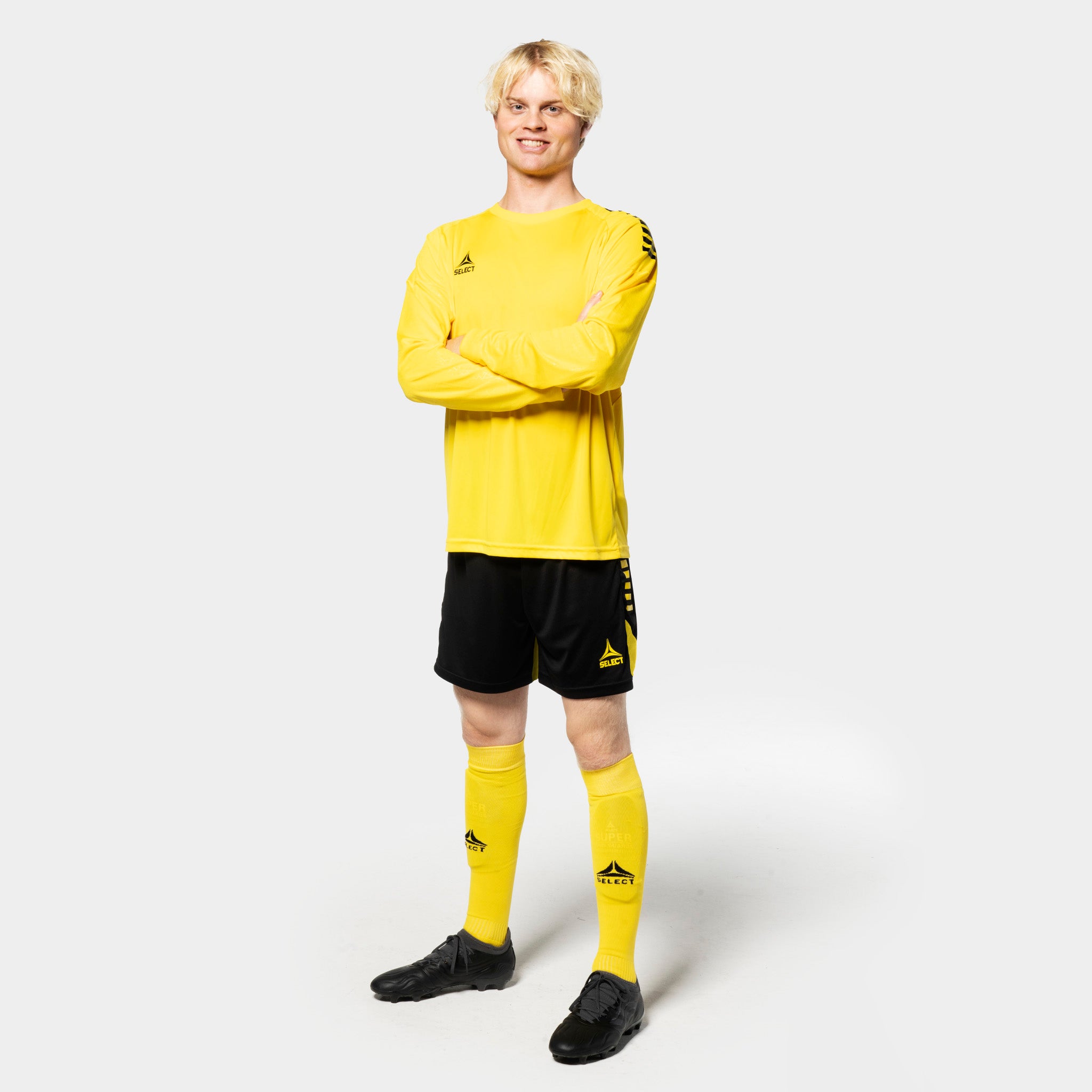 Male football player in yellow Player shirt L/S Spain v25, black shorts, yellow socks. Match & Training wear, front view.