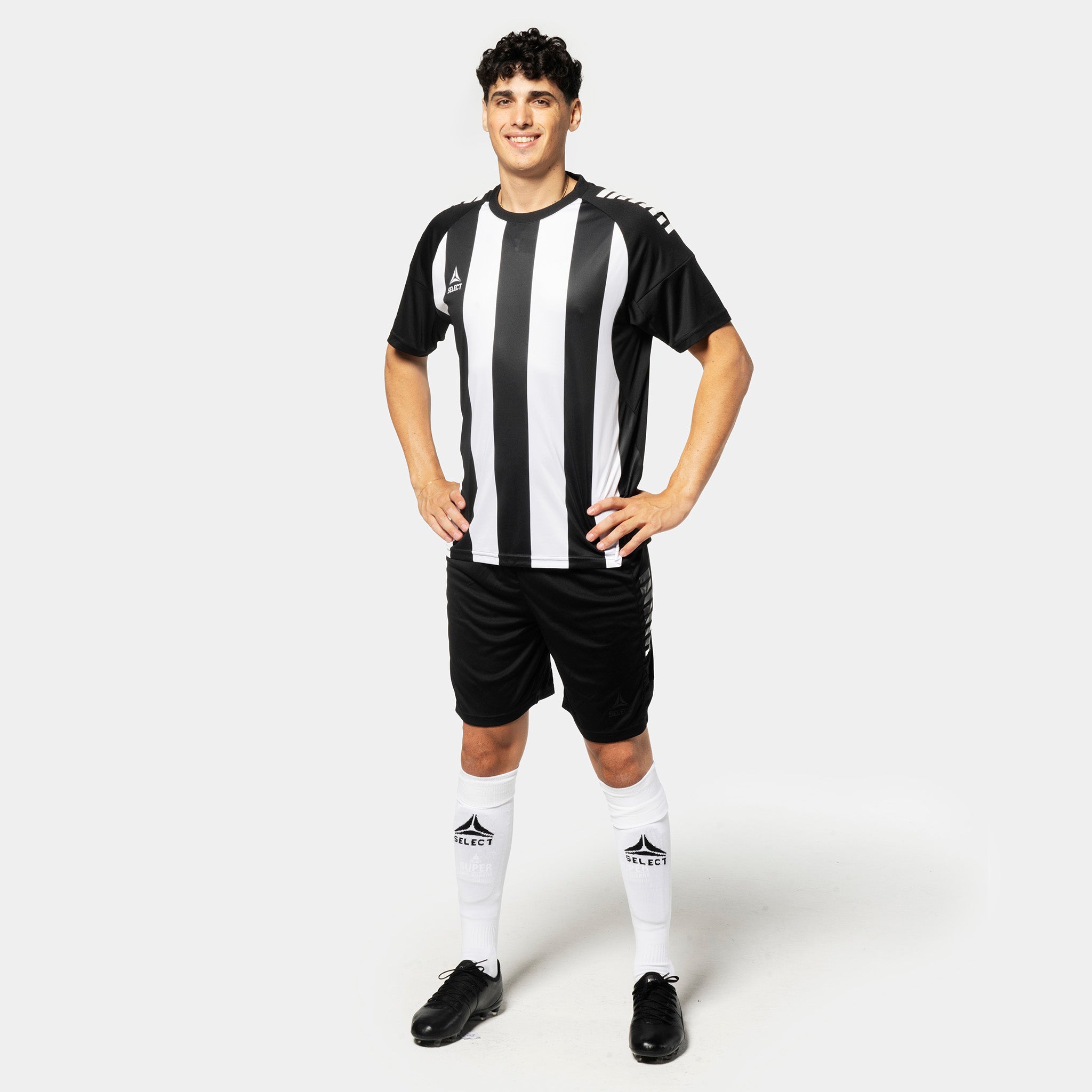 Man in black and white striped Player shirt S/S Spain v25, black shorts, white socks. Football Match & Training wear, front view.