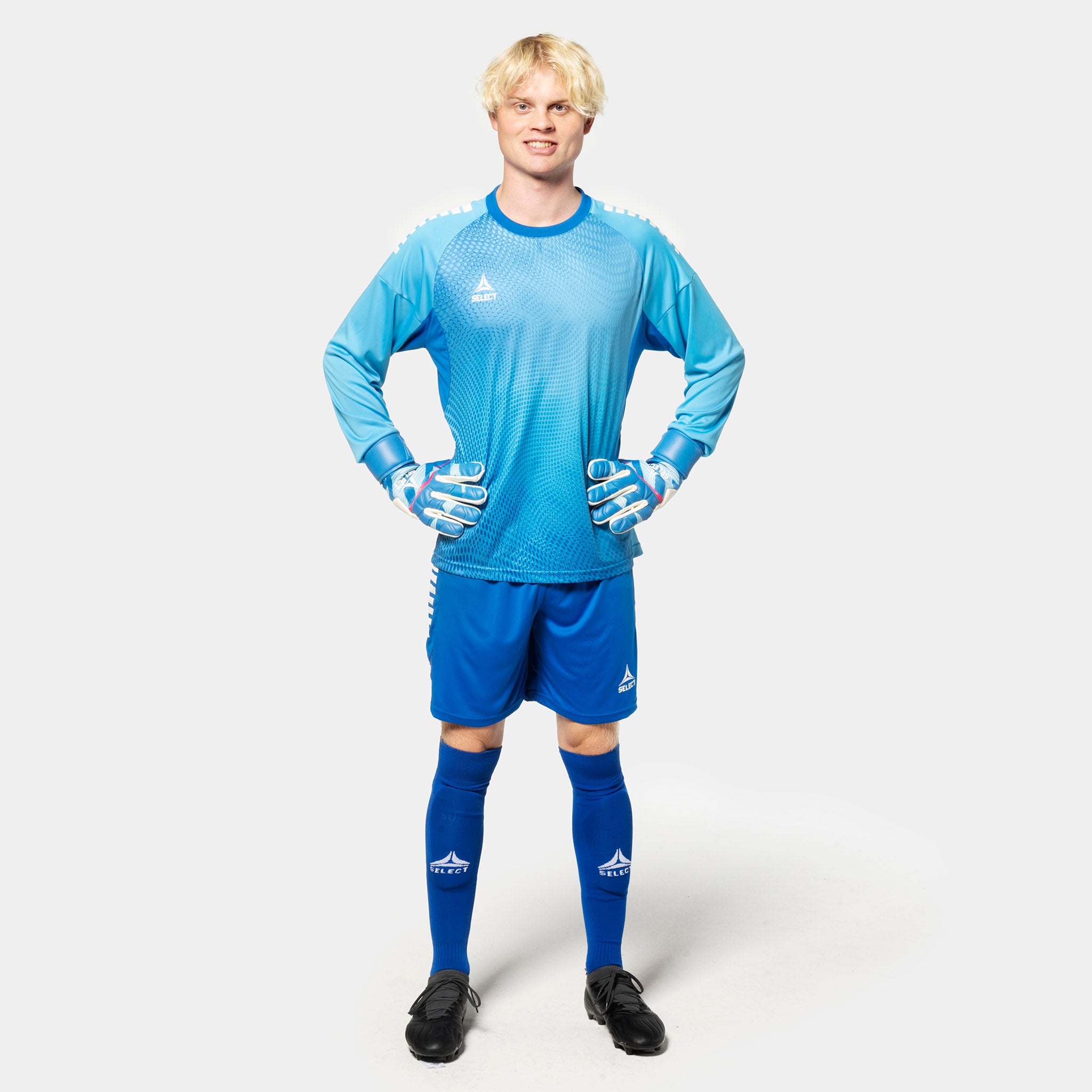 Male football player in blue Player shorts Spain v25 goalkeeper wear, front view with light blue shirt and gloves.