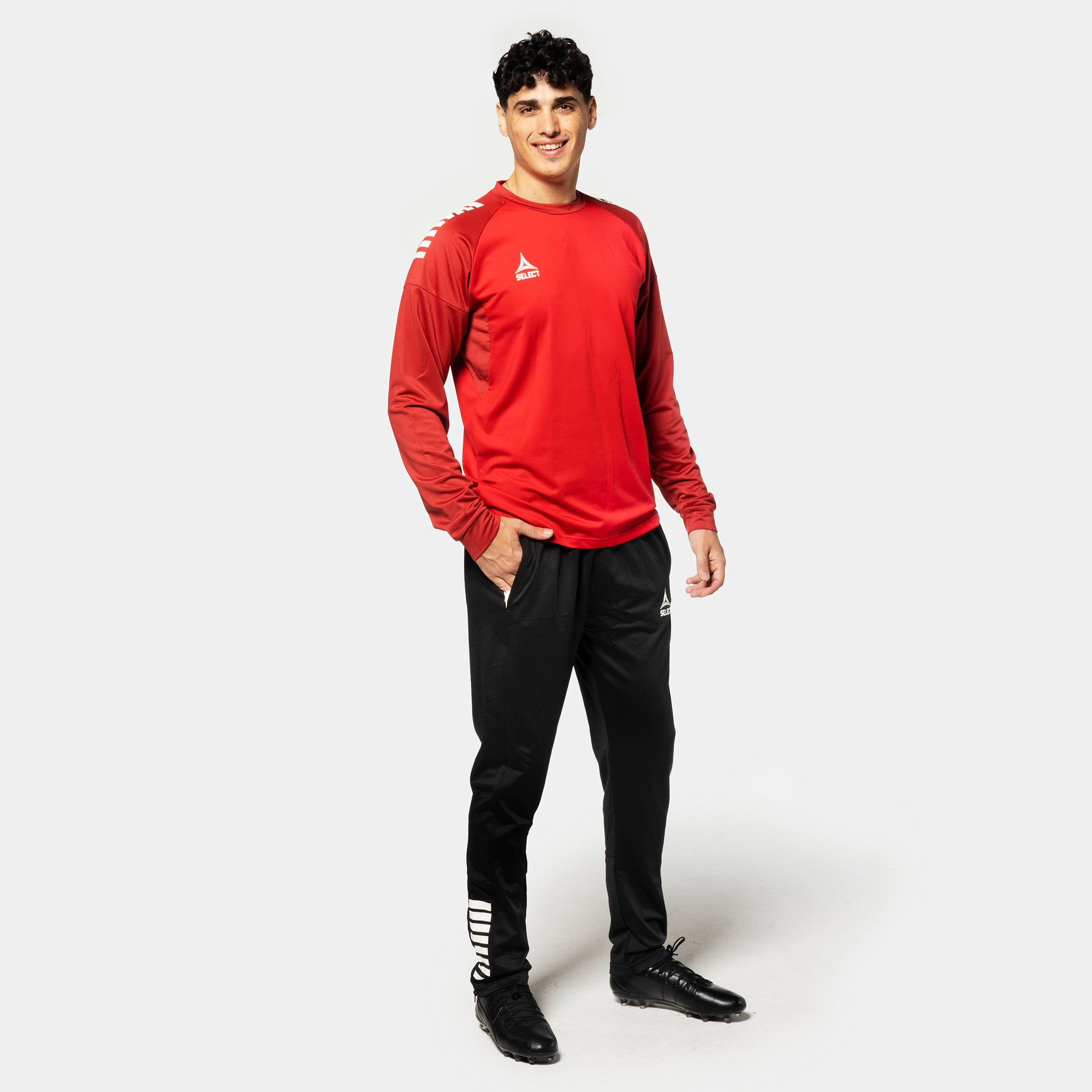 Male football player in red and white Training sweat Spain v25, Match & Training wear, with black pants, front view