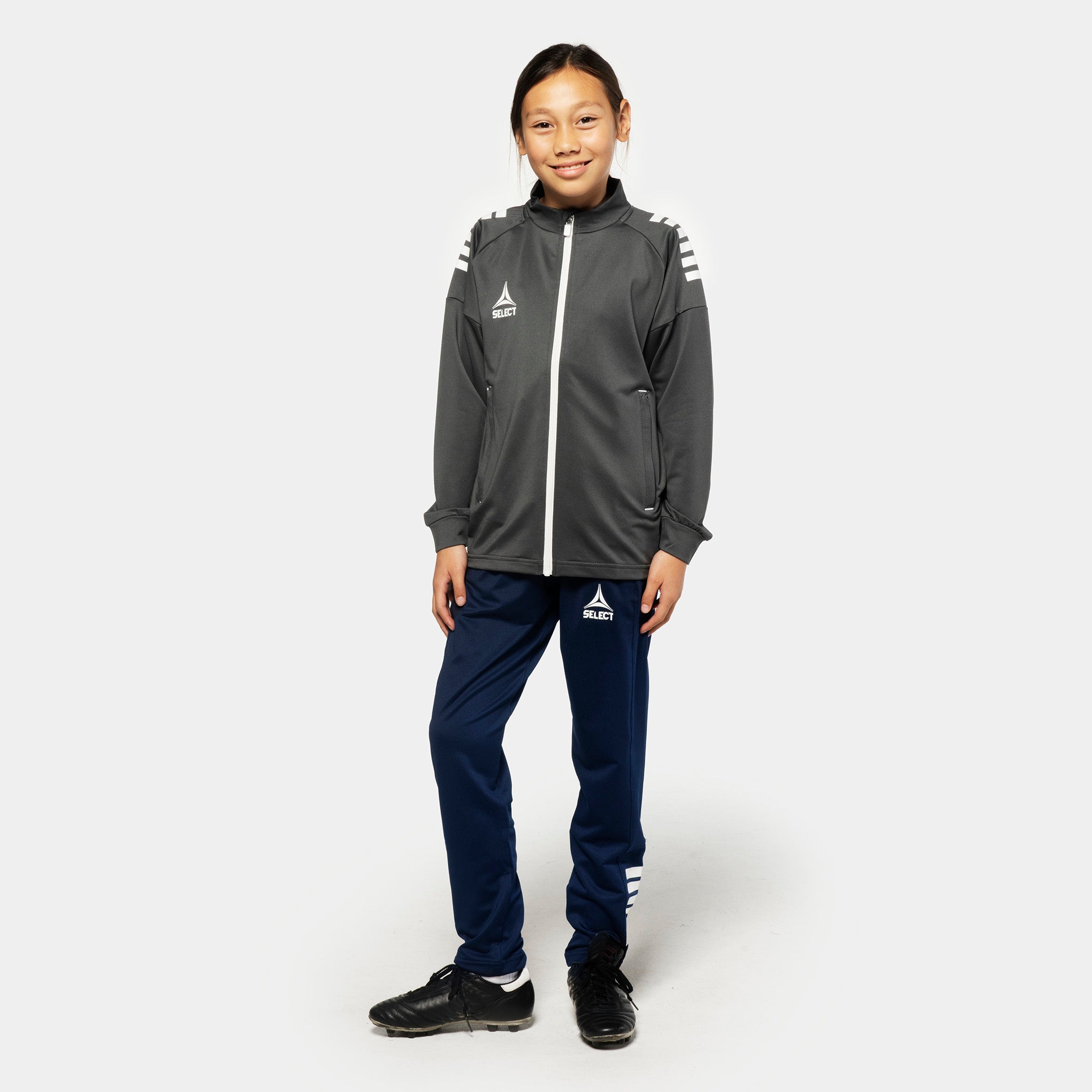 Girl football player wearing grey-white Training zip jacket and navy Training pants regularFit Spain v25, Match & Training wear, front.