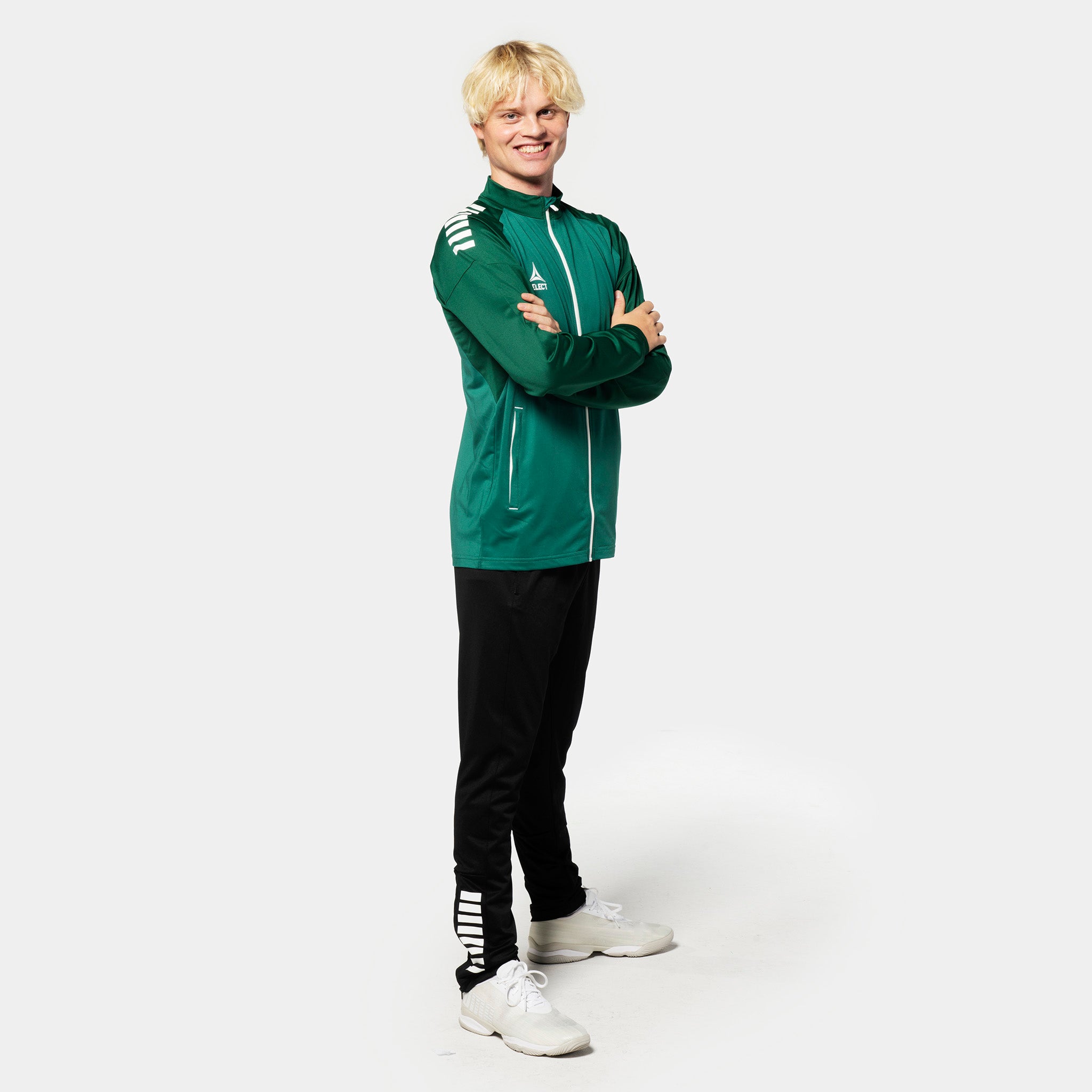 Male football player in green Training zip jacket Spain v25, black pants. Match & Training wear.