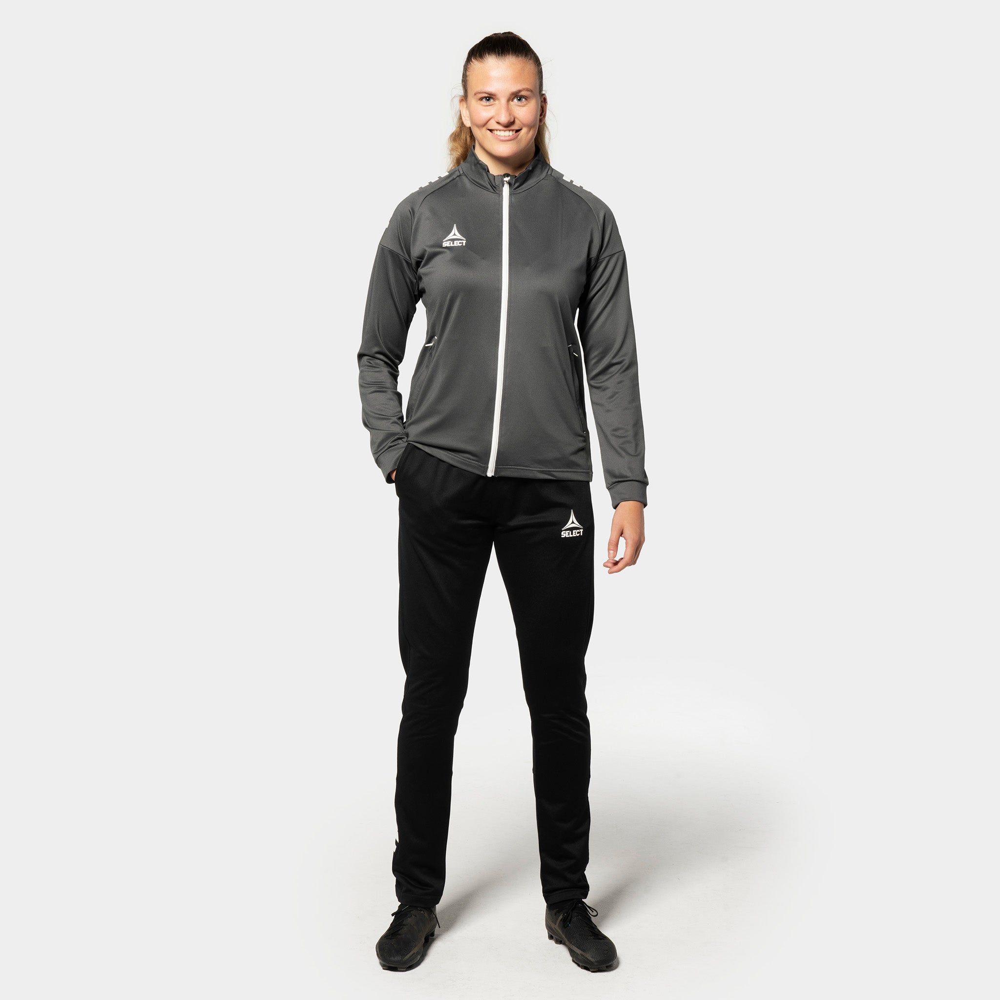 Woman football player in grey-white Training zip jacket Spain woman v25, Match & Training wear, black pants, front view