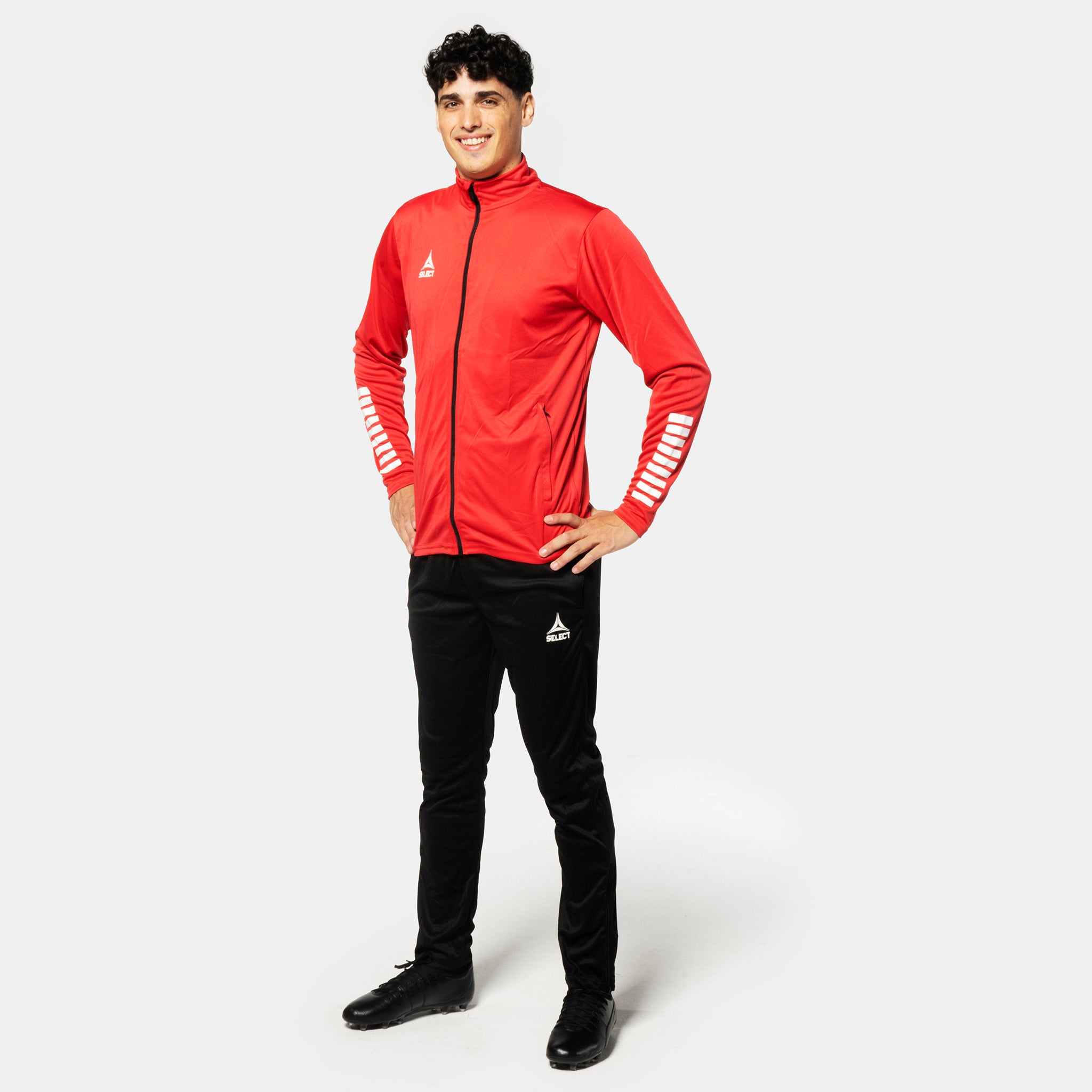 Male football player in red zip jacket and black Training pants regular fit Pisa, Match & Training wear, front view.