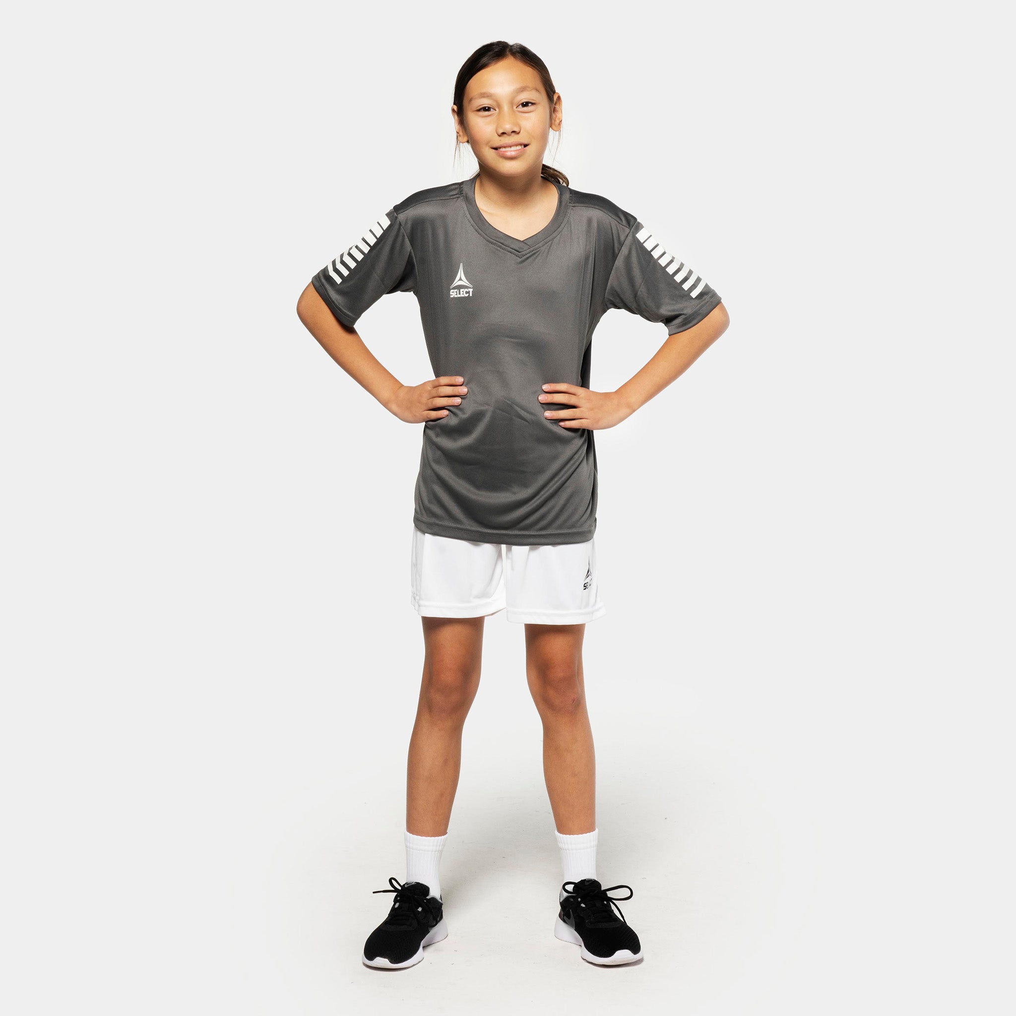 Girl football player wearing grey shirt and white Player shorts Pisa, Match & Training wear, front view.