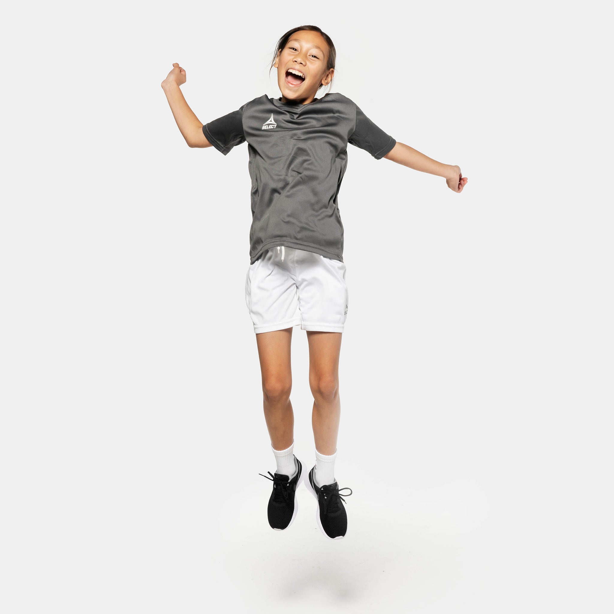 Boy football player jumping in grey shirt and white Player shorts Pisa from Match & Training wear collection.
