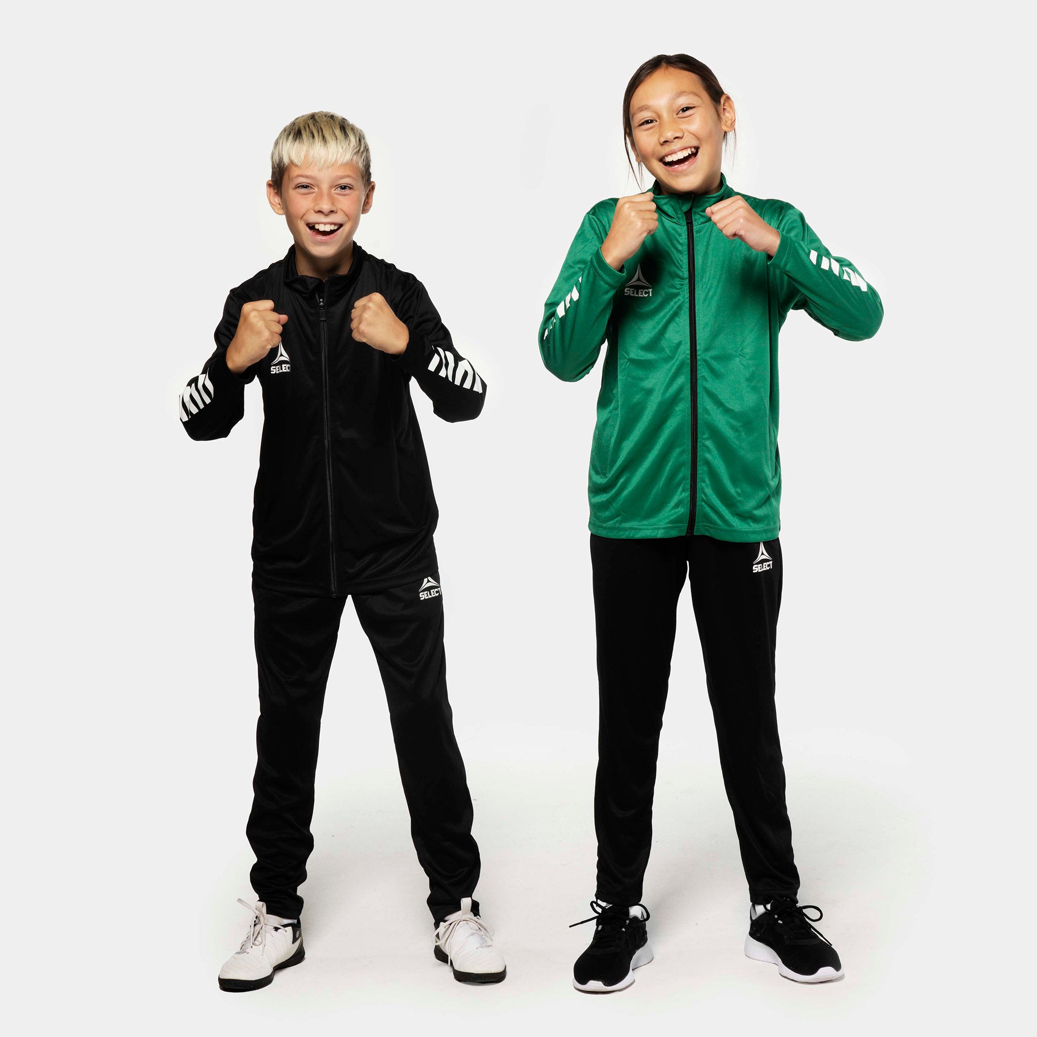 Kids football players in Pisa regular fit training pants, black, with black and green Match & Training jackets, front view.