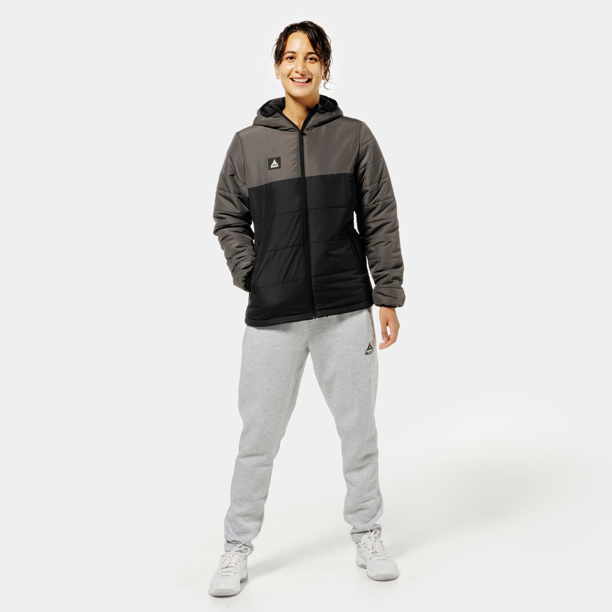 Woman football player in grey Sweat pants Oxford women v25 and black-grey padded jacket, leisure wear front view.