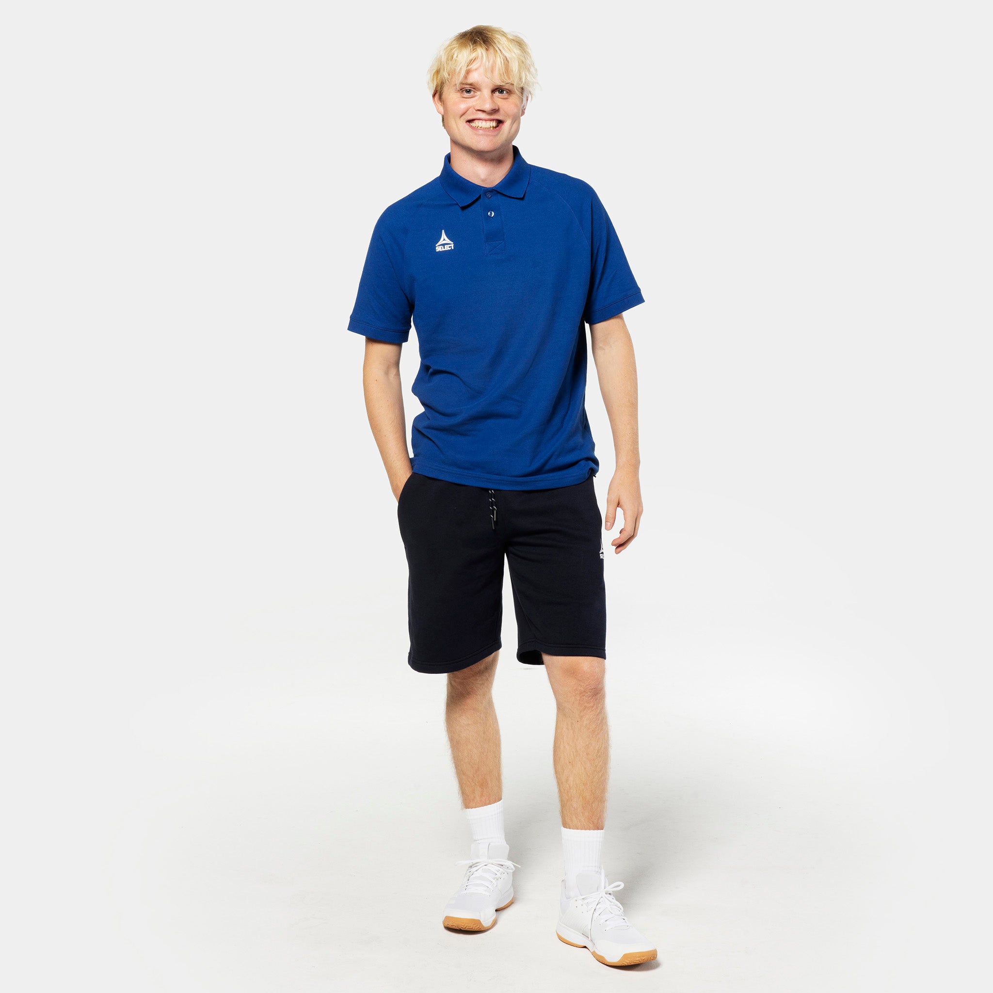 Man football player in blue polo and black Sweat shorts Oxford v25, leisure wear, front view.