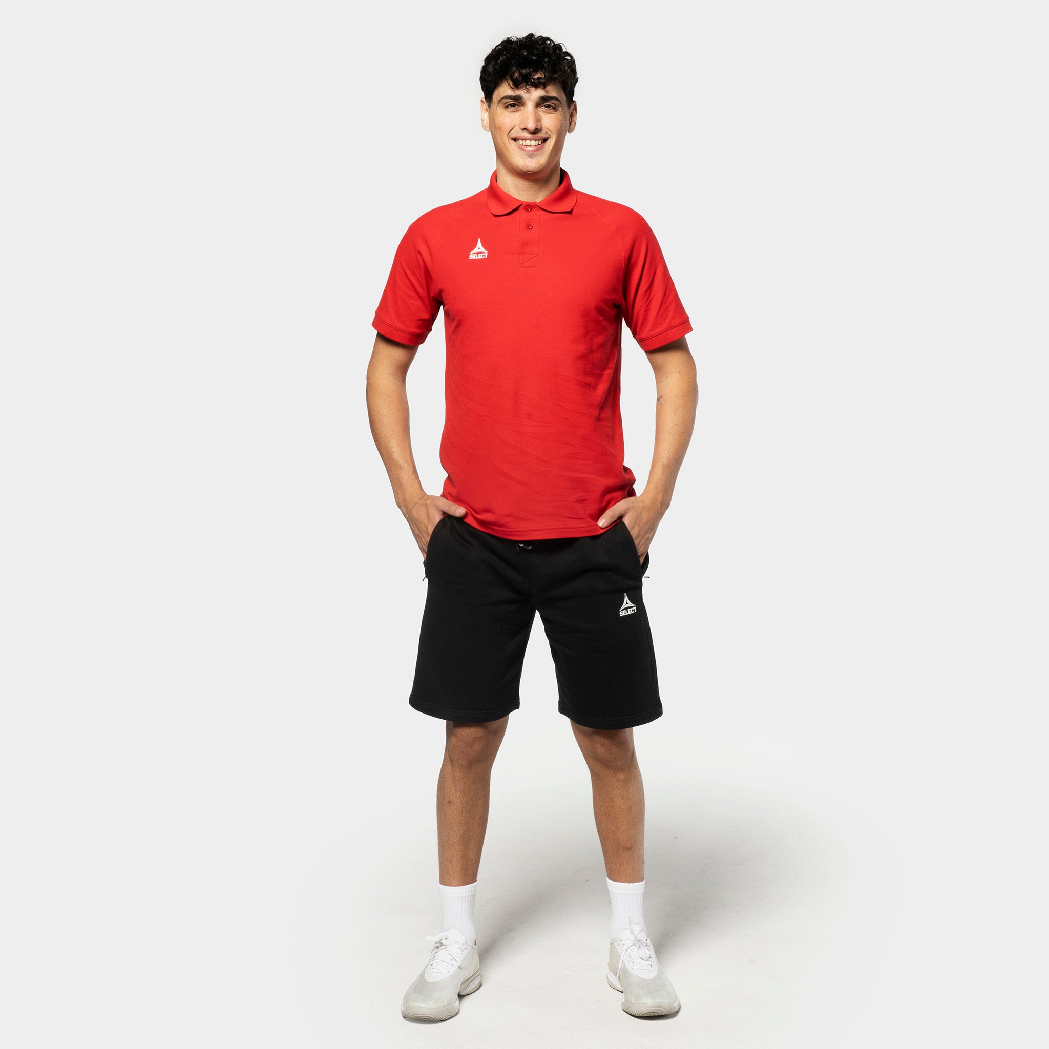Man in red polo and black Sweat shorts Oxford v25, leisure wear, football player front view.