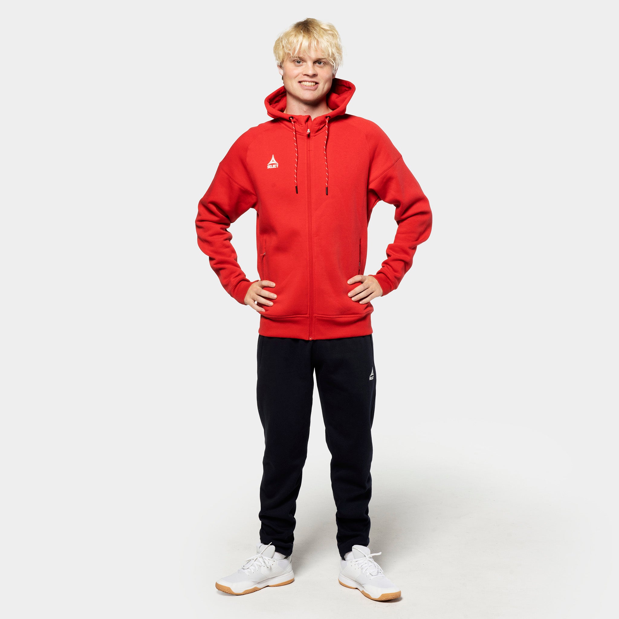 Man footballer in red zip hoodie and black Sweat pants Oxford v25, leisure wear, front view.