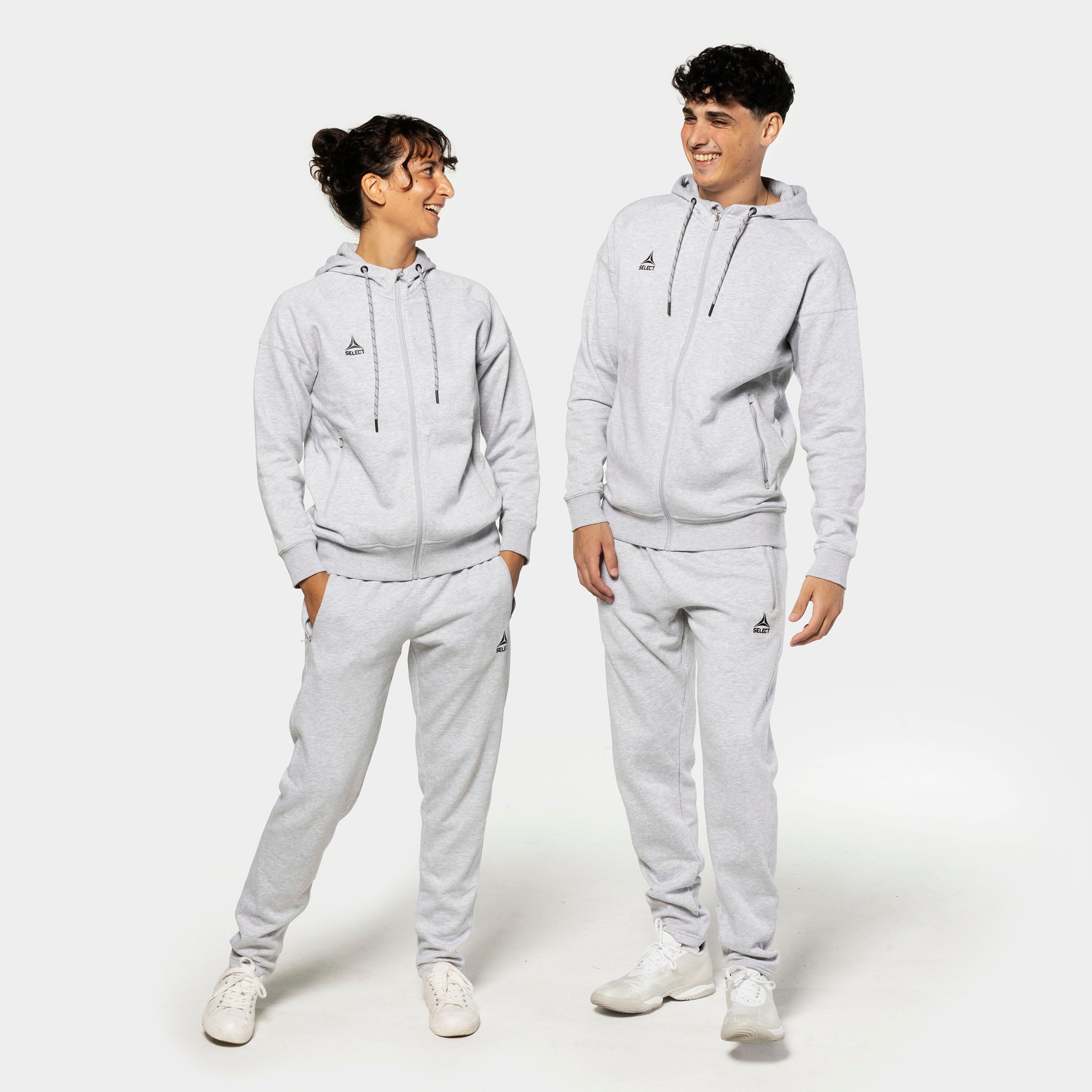 Woman and man football models in grey Sweat pants Oxford women v25 leisure wear with matching zip hoodies, front view.