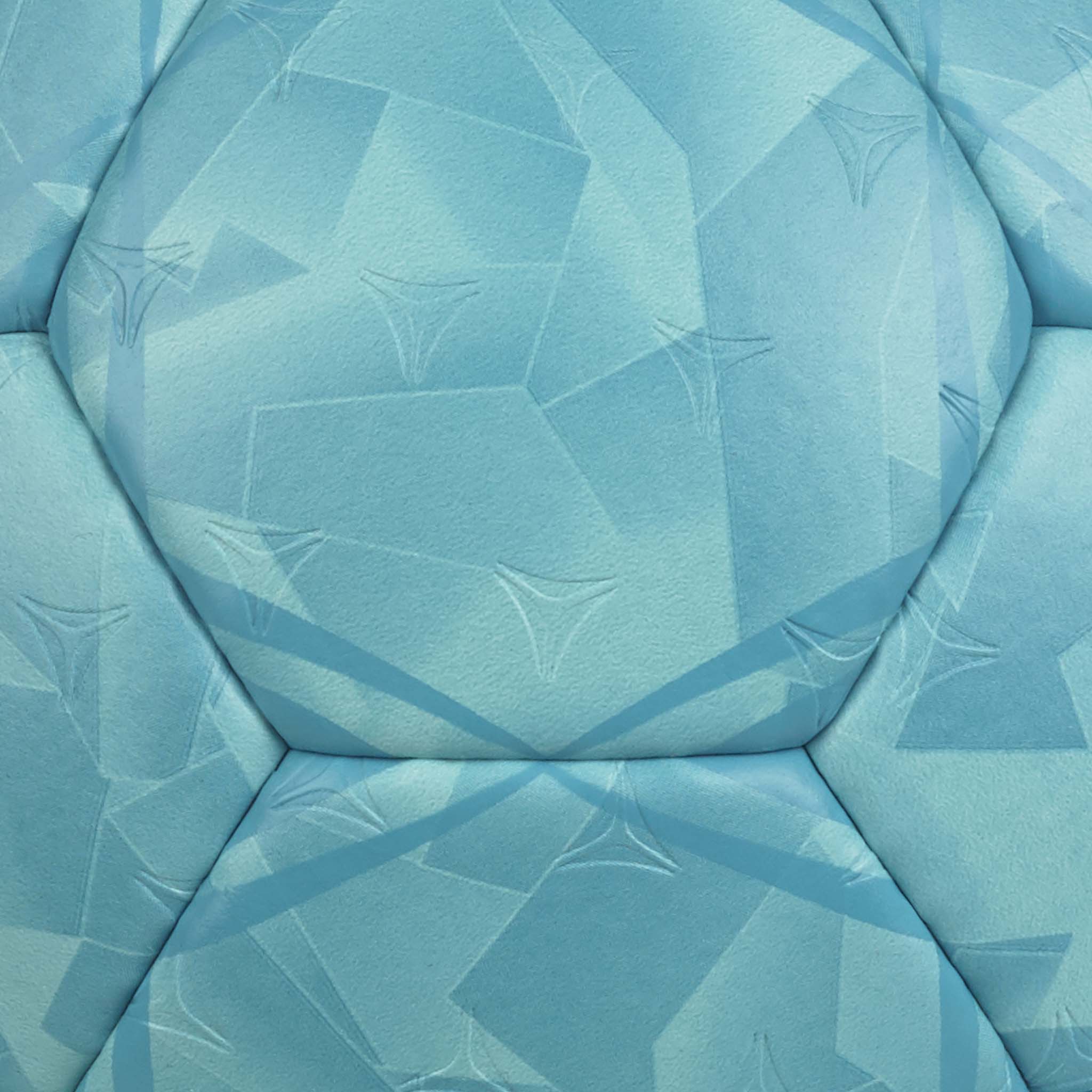Closeup of blue Solera v26 handball, showing textured panels with geometric patterns in shades of light blue and teal.