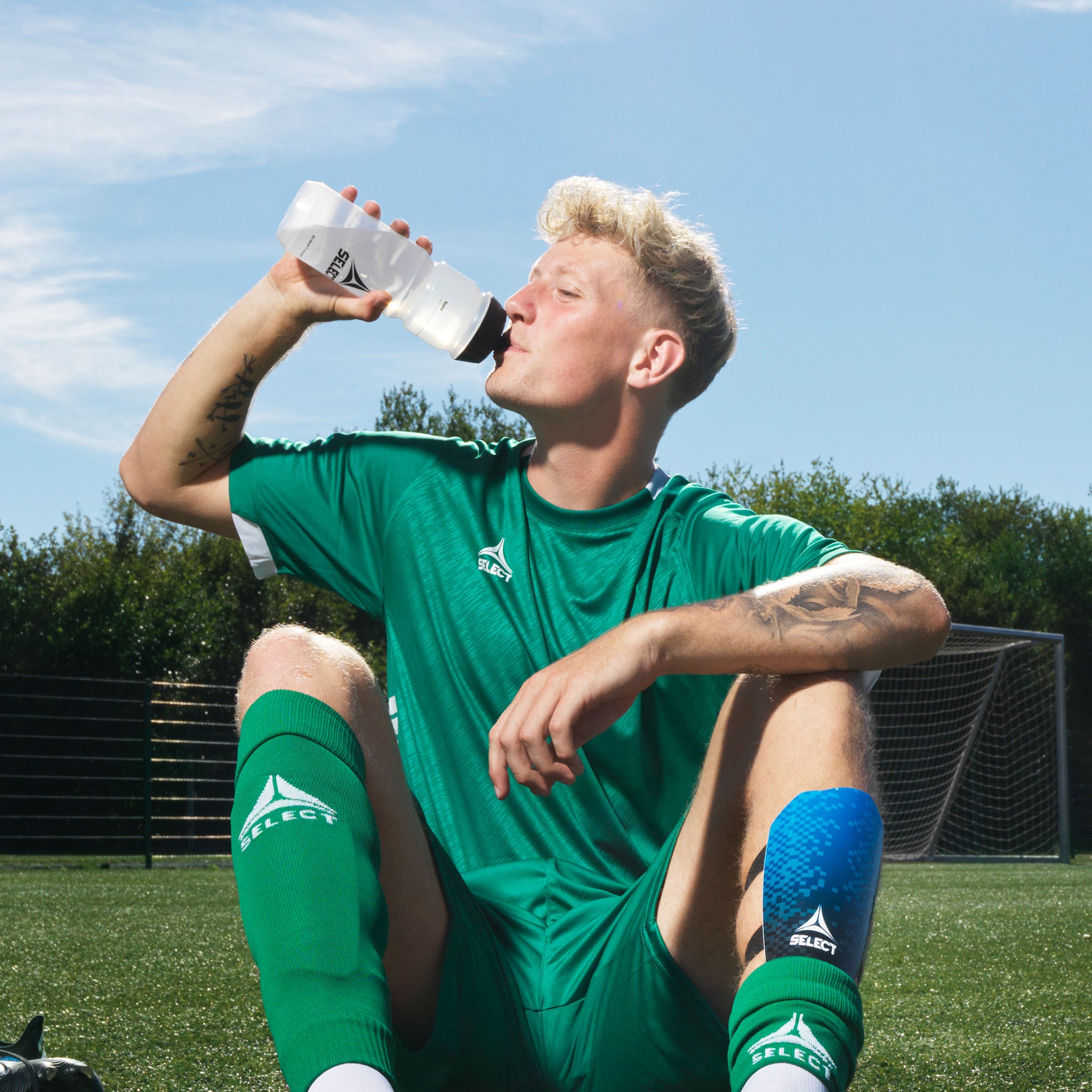 White Select v21 water bottle with red detail, used by a football player on the pitch. Other teamgear & training equipment.