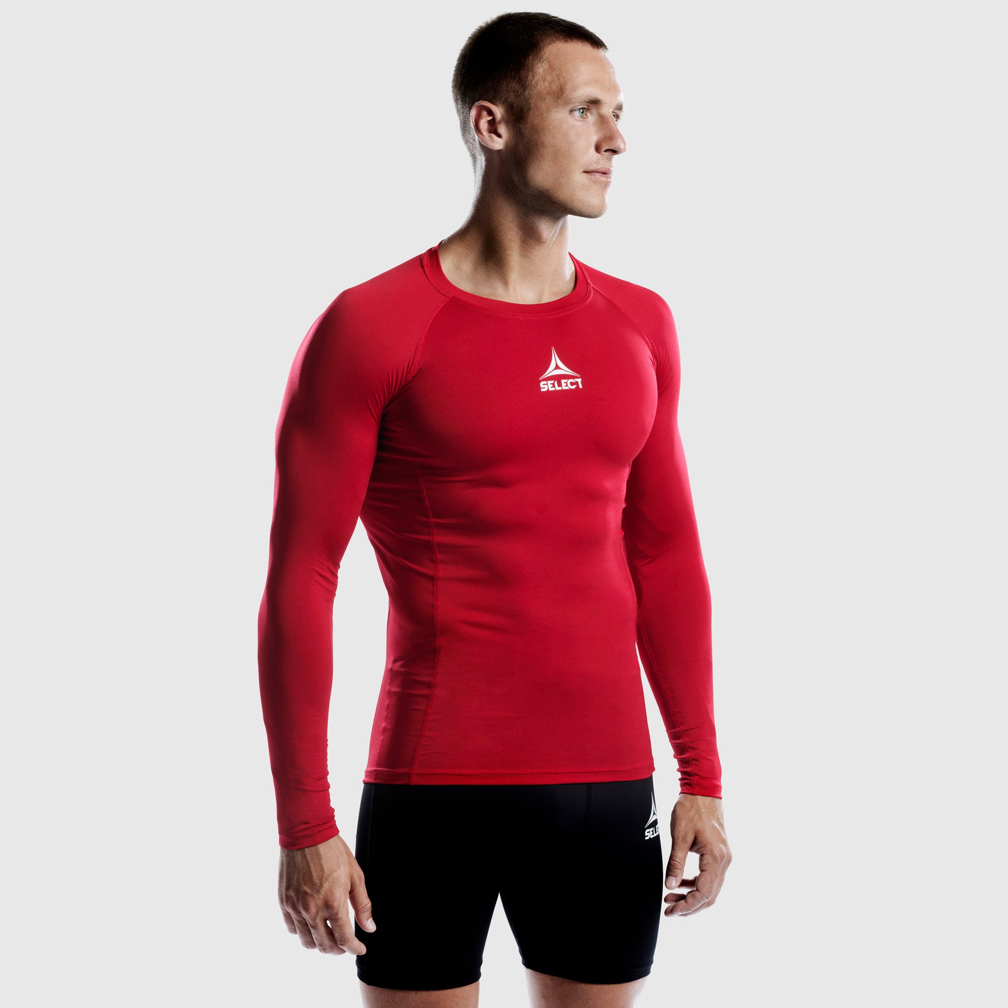 Man football player in red Shirts L/S Baselayer, front view, with black shorts
