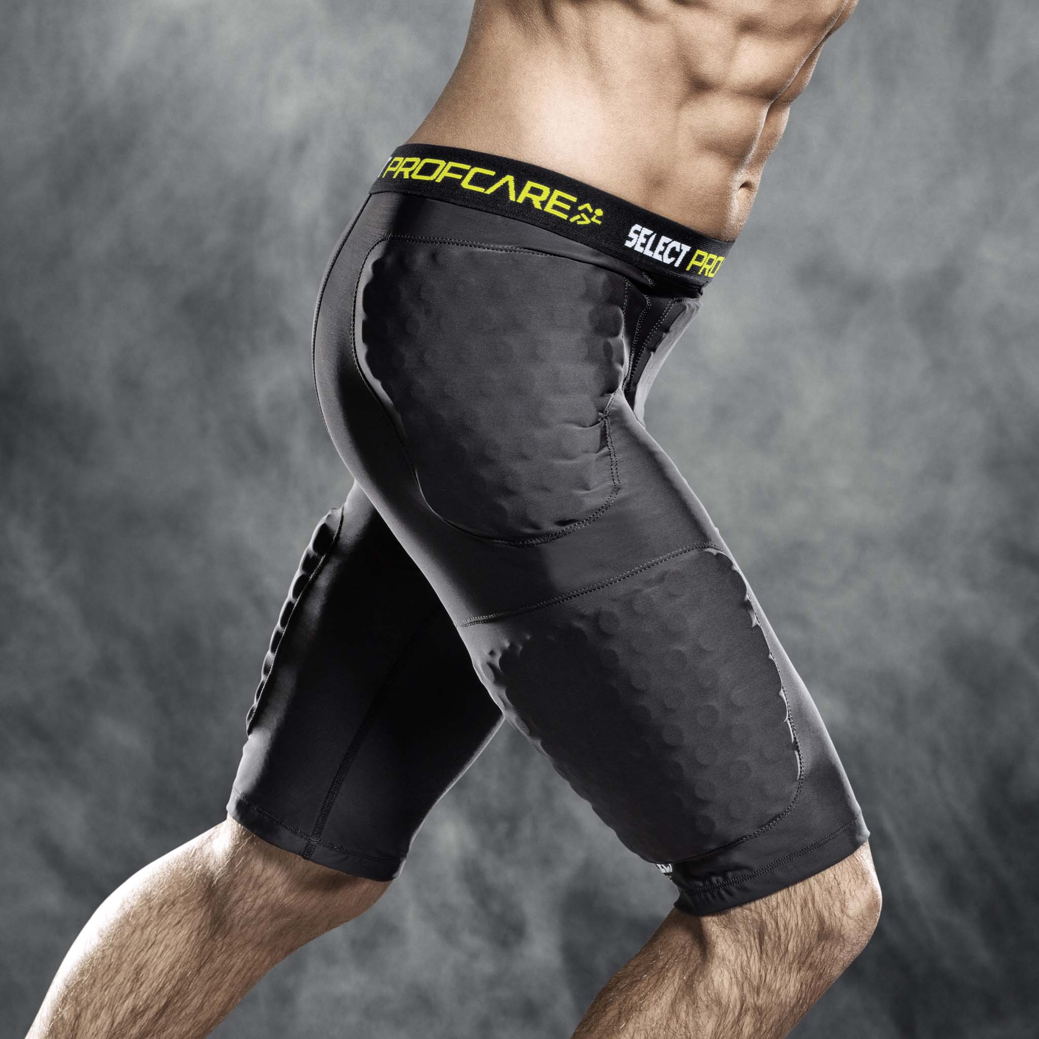 Mand iført sorte Compression shorts w/pads 6421, sportsstøtte med gule detaljer, fodboldspiller, set forfra