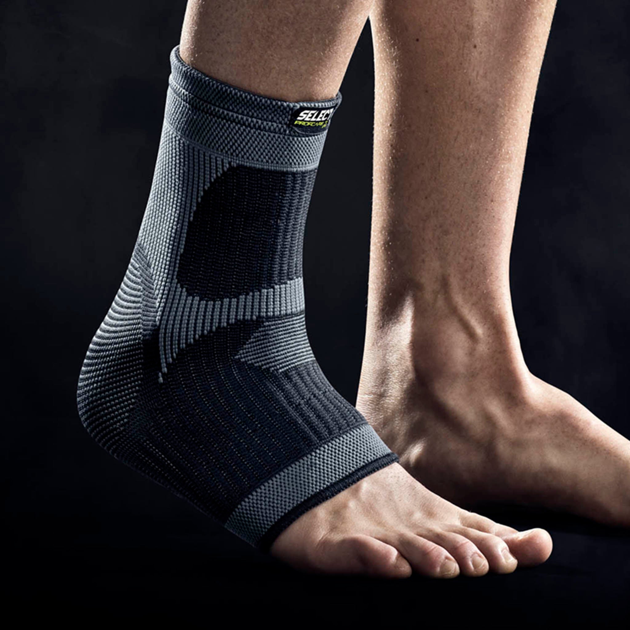 Sort og grå ankelbandage, sportsstøtte, båret af en fodboldspiller