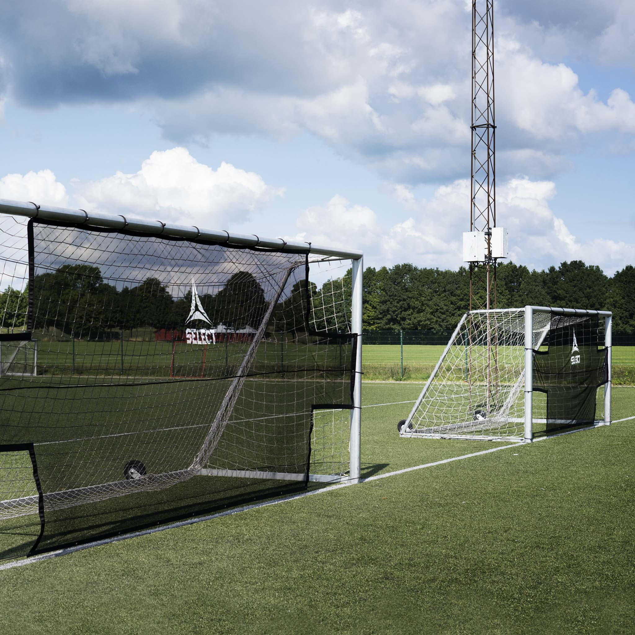 Front page view of black Goal net training equipment on a green football field
